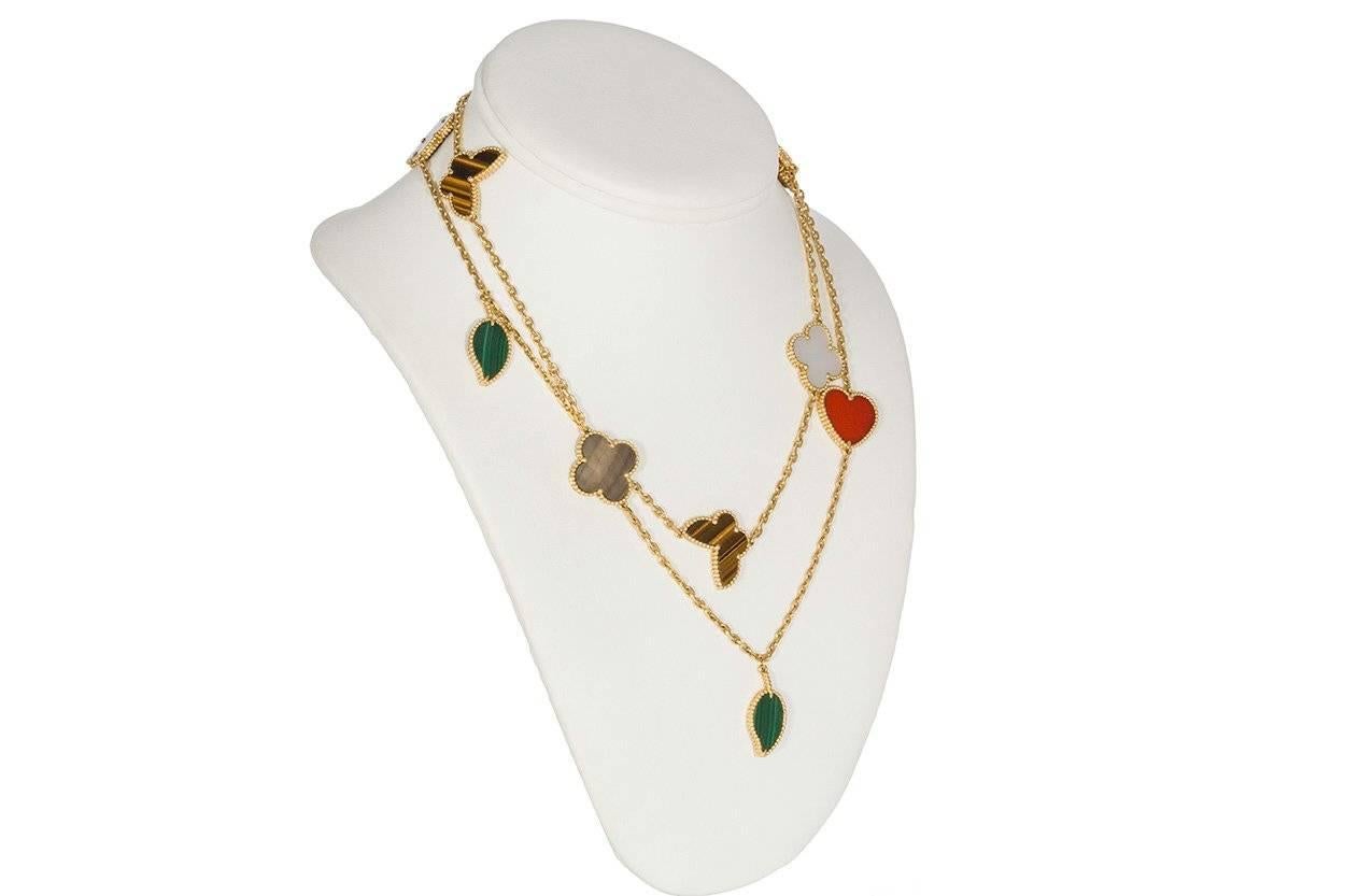 We are pleased to offer these beautiful Guaranteed Authentic Van Cleef & Arpels 18k Yellow Gold Lucky Alhambra 12 Motif Necklace. This stunning necklace features white and gray Mother-of-Pearl, Malachite, Tiger's Eye and Carnelian all finely set