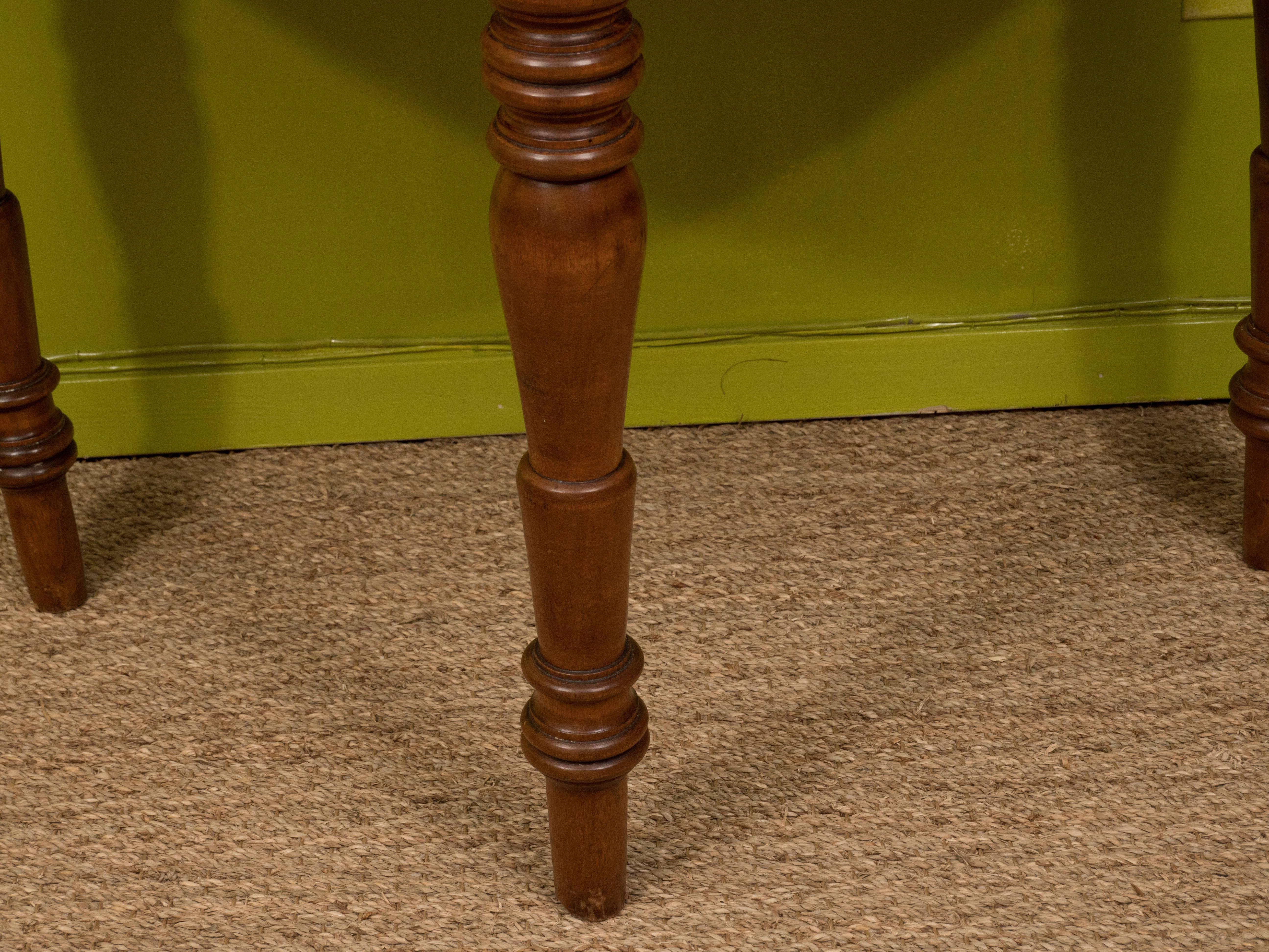 A charming demilune table in oak on turned legs, circa 1900.