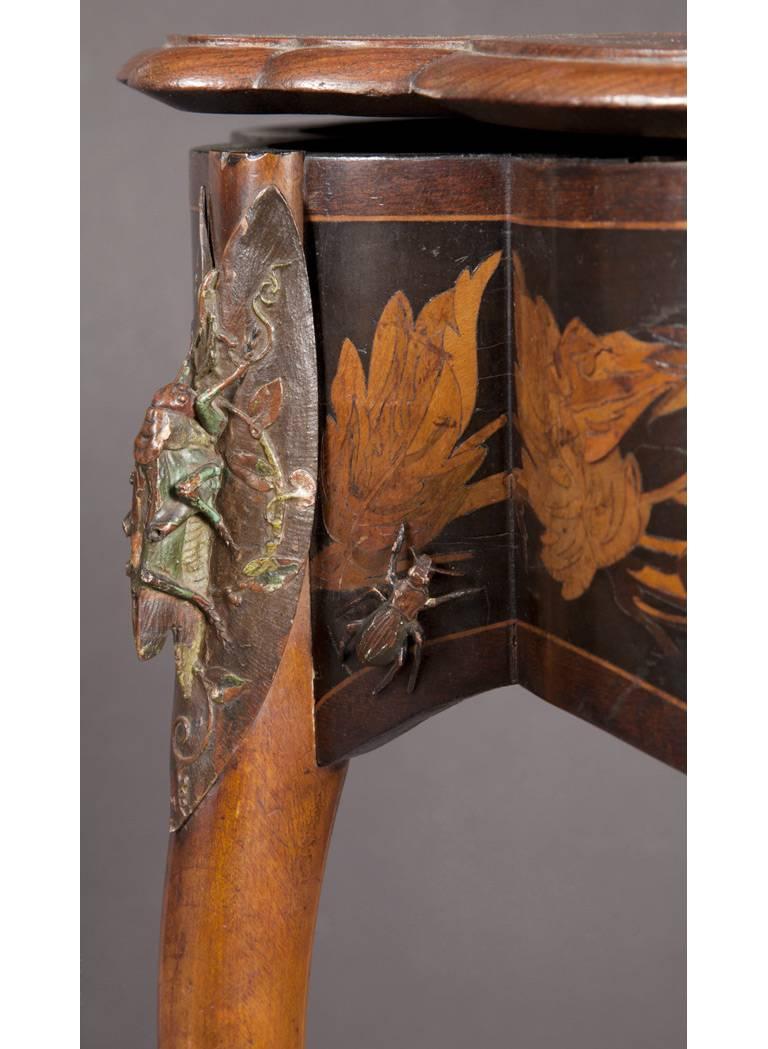 Charles-Guillaume Diehl

A rare and fine cold-painted and enameled copper mounted fruitwood inlaid table
Paris, circa 1878

The table, opening to reveal a cushioned interior in red silk, raised on three intertwined curved legs with the front