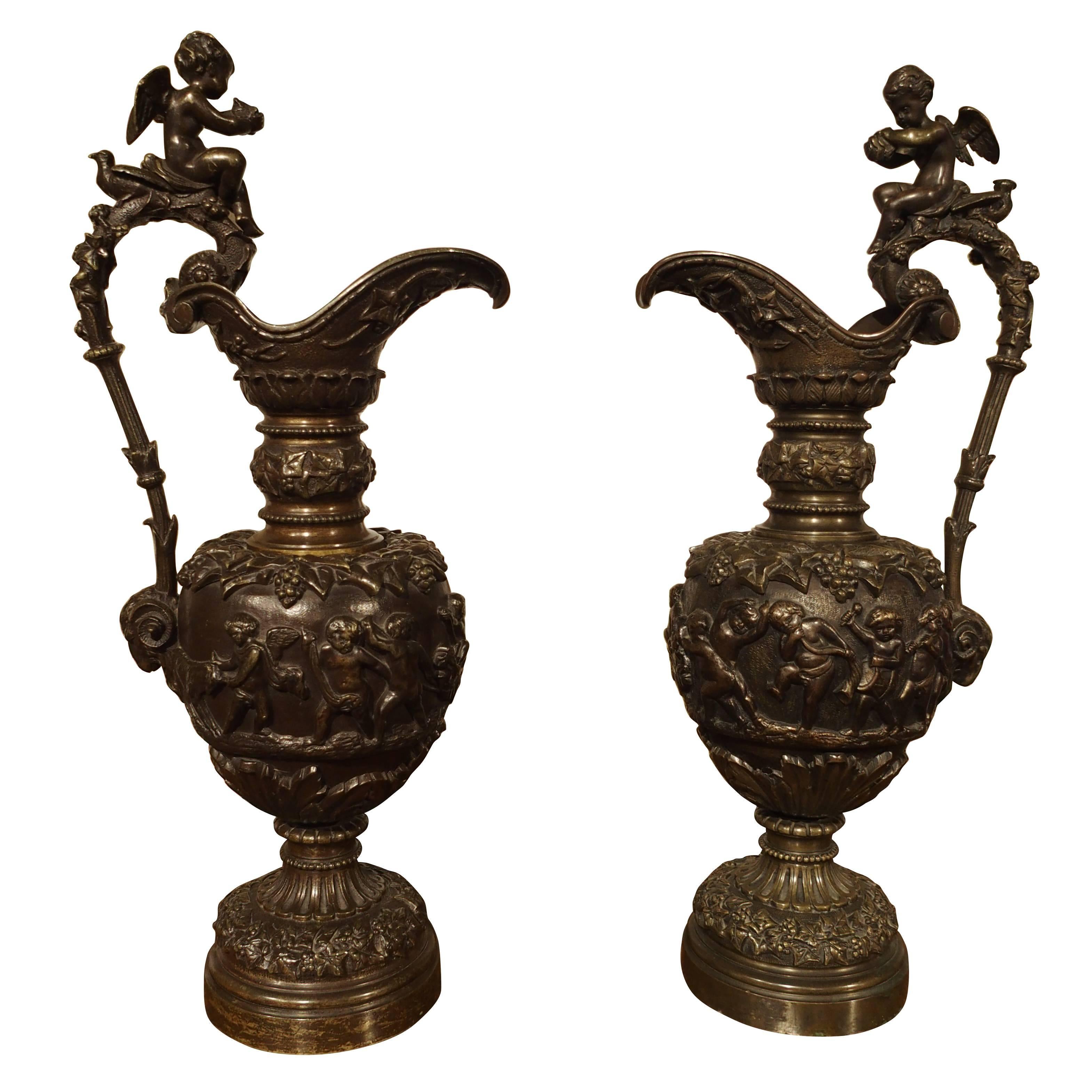 A Pair of Antique French Patinated Bronze Ewers with Bacchanalian Scenes For Sale