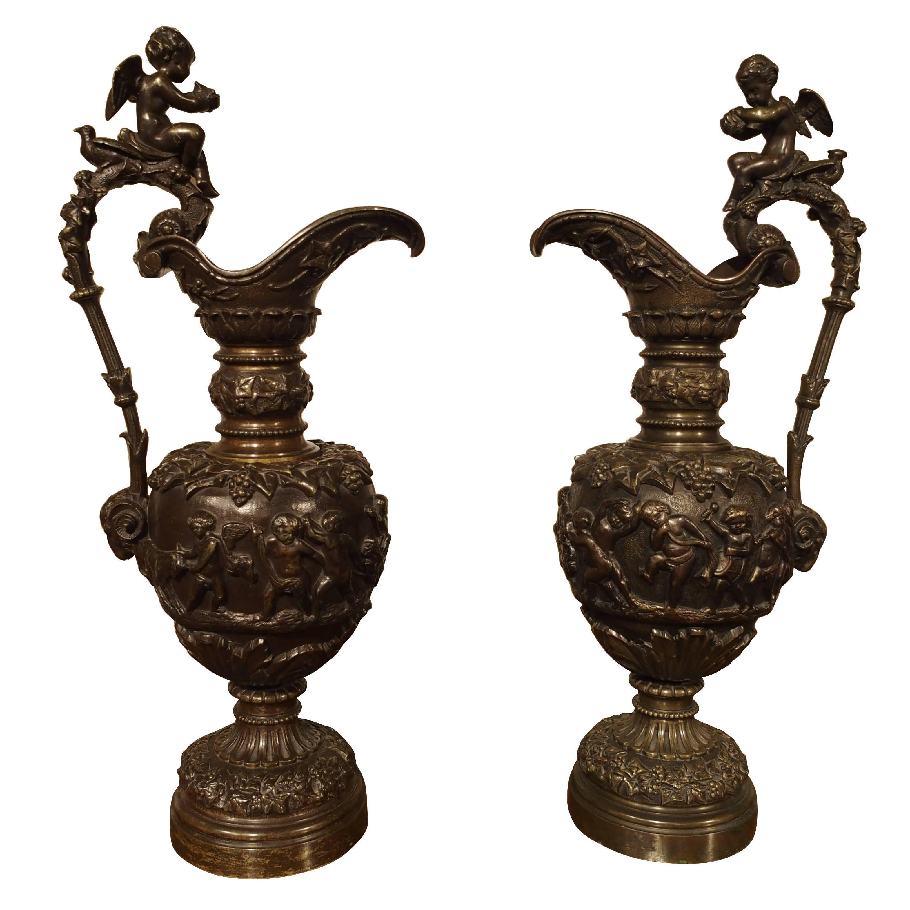Pareja de antiguos aguamaniles franceses de bronce patinado con escenas bacanales en venta