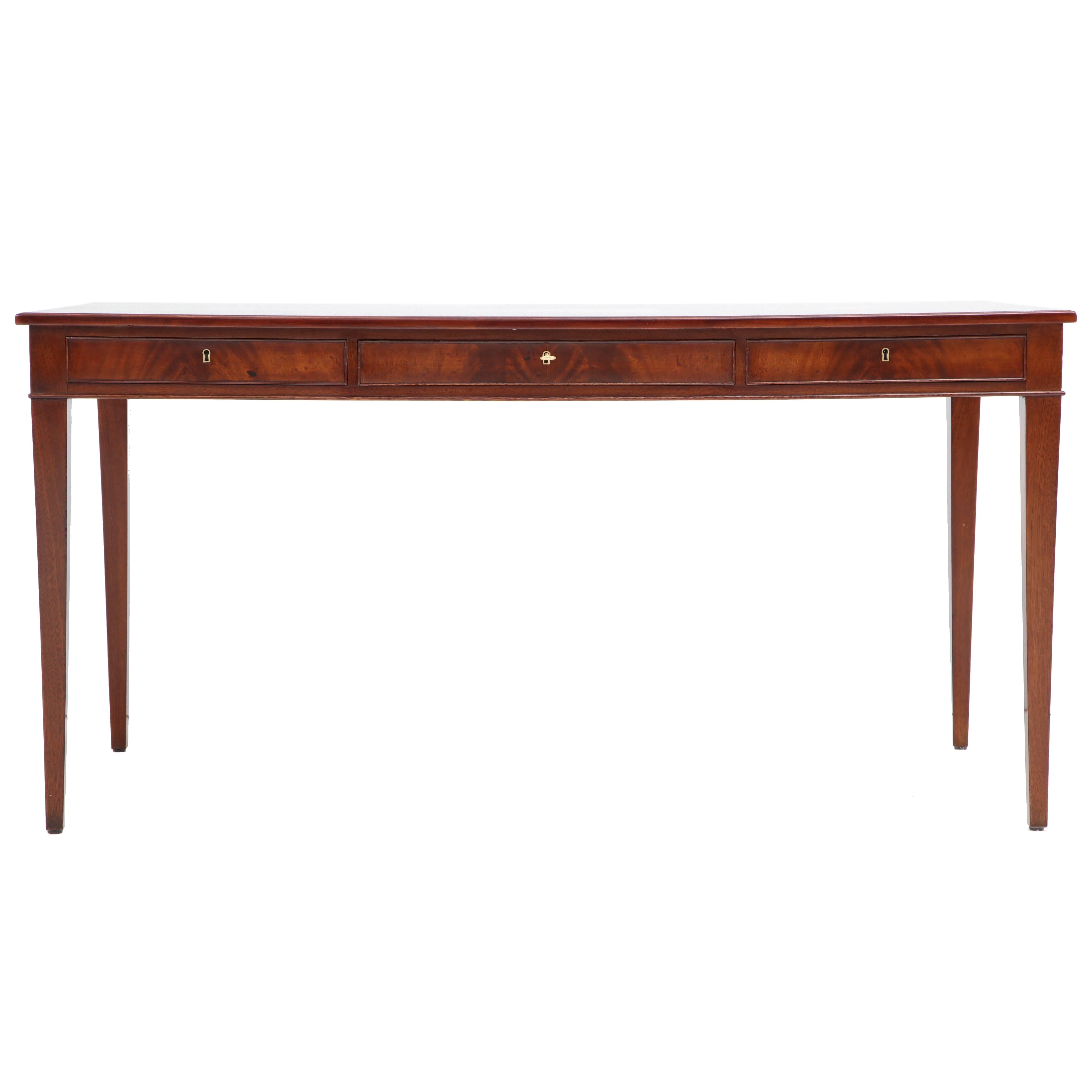 A Danish mahogany writing table by Frits Henningsen, furniture designer and cabinet maker (1889-1965). This desk is a classic example of Henningsen's elegant clean lines and use of quality woods with perfect balanced craftsmanship. A rectangular top