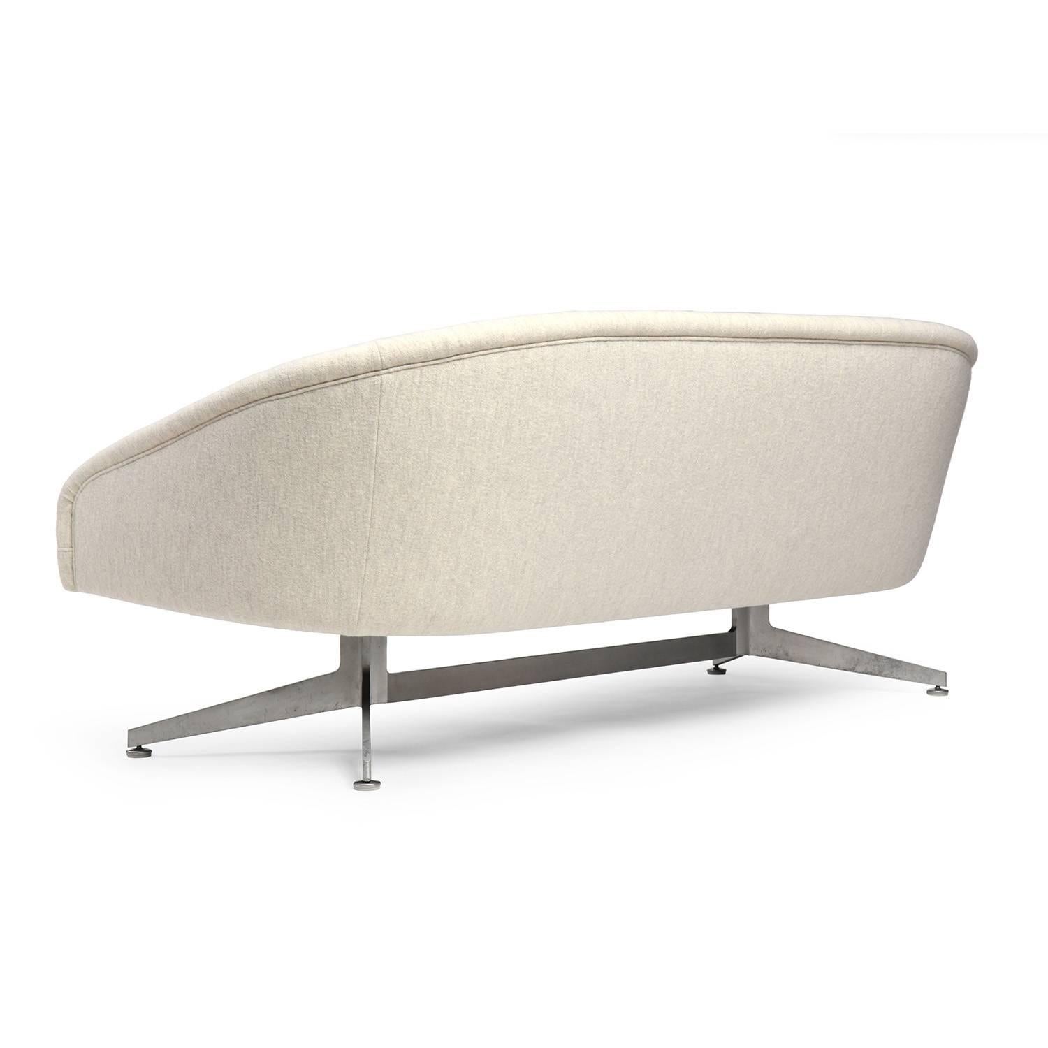 A modernist and sculptural barrel back sofa having tapered arms floating on a satin aluminum double Y-form legged base.