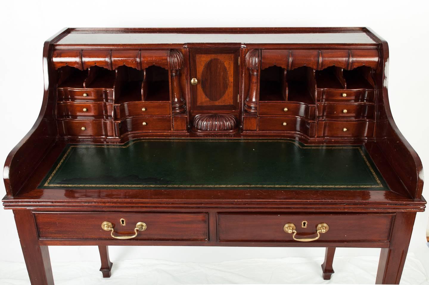 Vintage secretary with embossed leather top and several storage compartments and two main drawers.