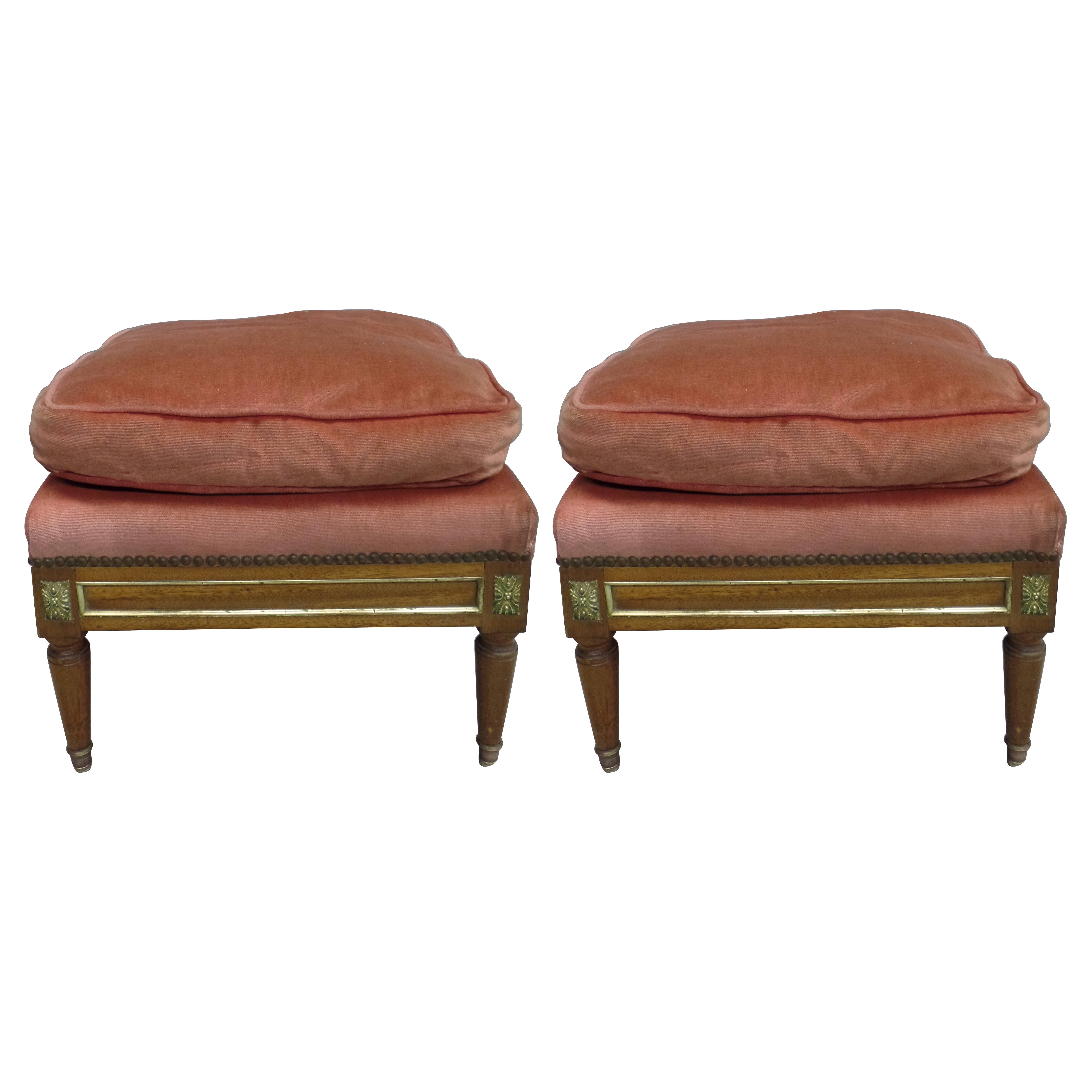 A pair of elegant Mid-Century Louis XVI style foot stools / ottomans / poofs in the modern neoclassical tradition with tapered legs ending in solid bronze sabots and brass decoration. Made by hand.