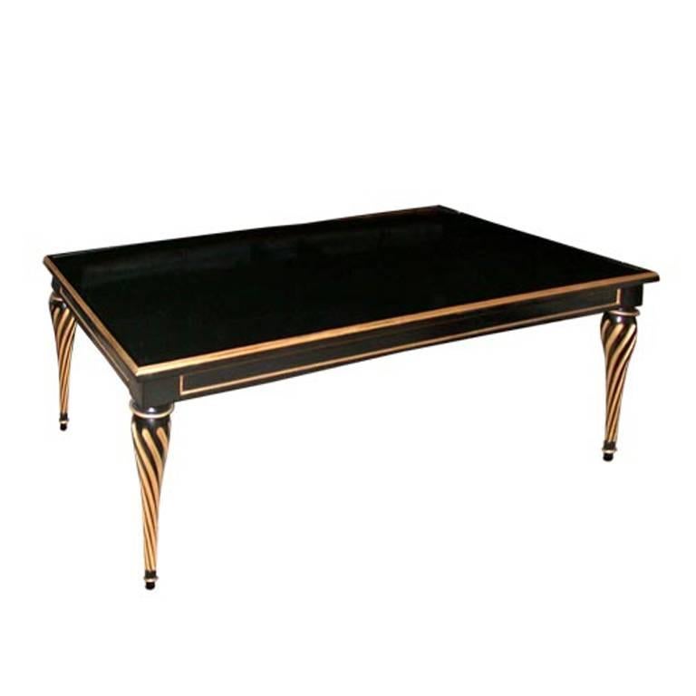 Parcel-gilt and black lacquer coffee table with turned wood legs. 
Signed: Jansen.