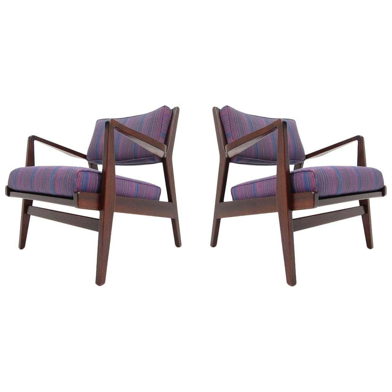 Pair of Jens Risom lounge chairs in walnut, circa 1965. Chairs have been completely refinished in a dark walnut and reupholstered, including new foam. Measures: Width 27