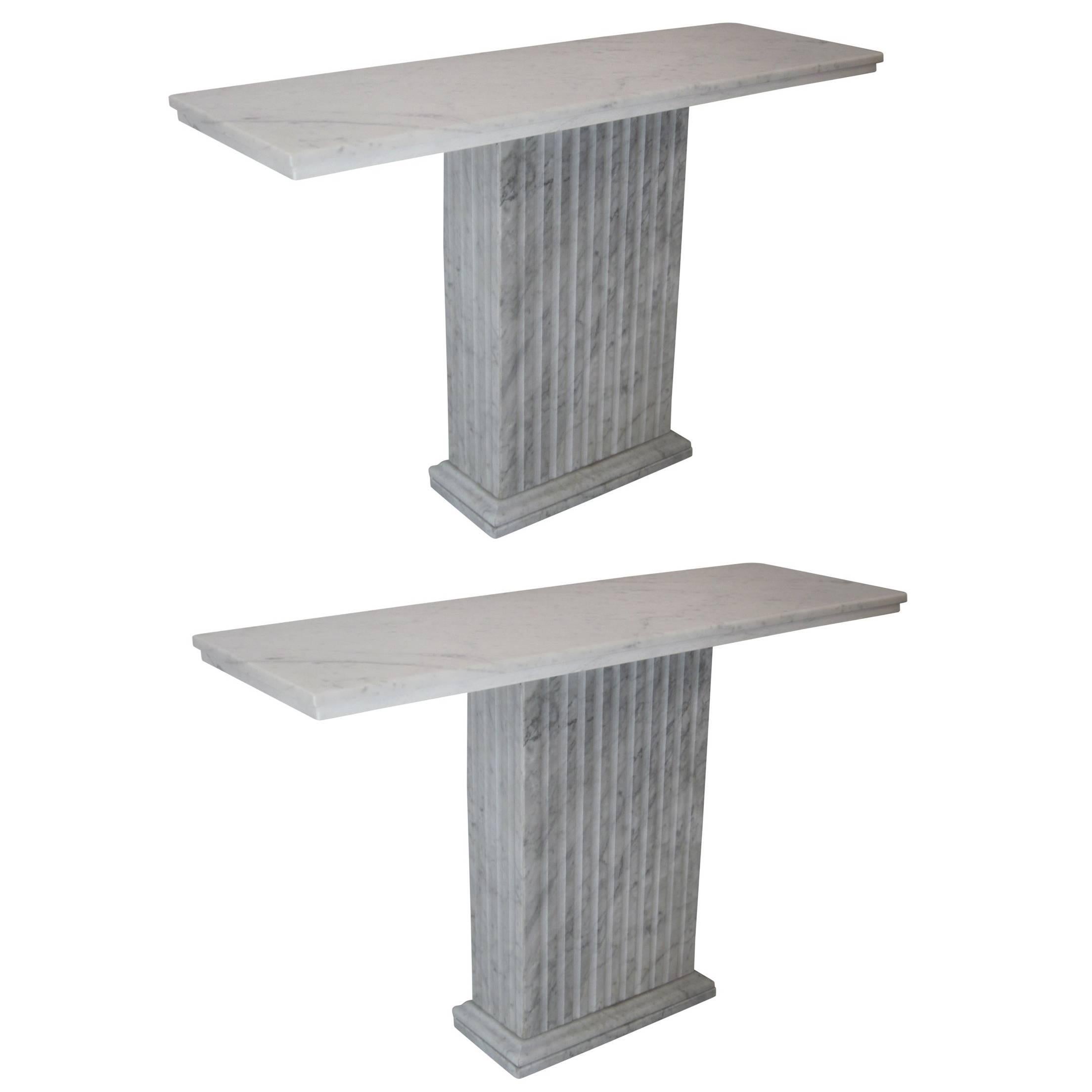 Timeless pair of Italian modern neoclassical marble consoles or sofa tables in the style of modernist architect Marcel Breuer. The pieces are in white Carrara marble and have perfect form, volume and lines reflecting elegance and total sobriety.