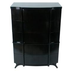 Tall serpentine front chest of drawers with tapered legs