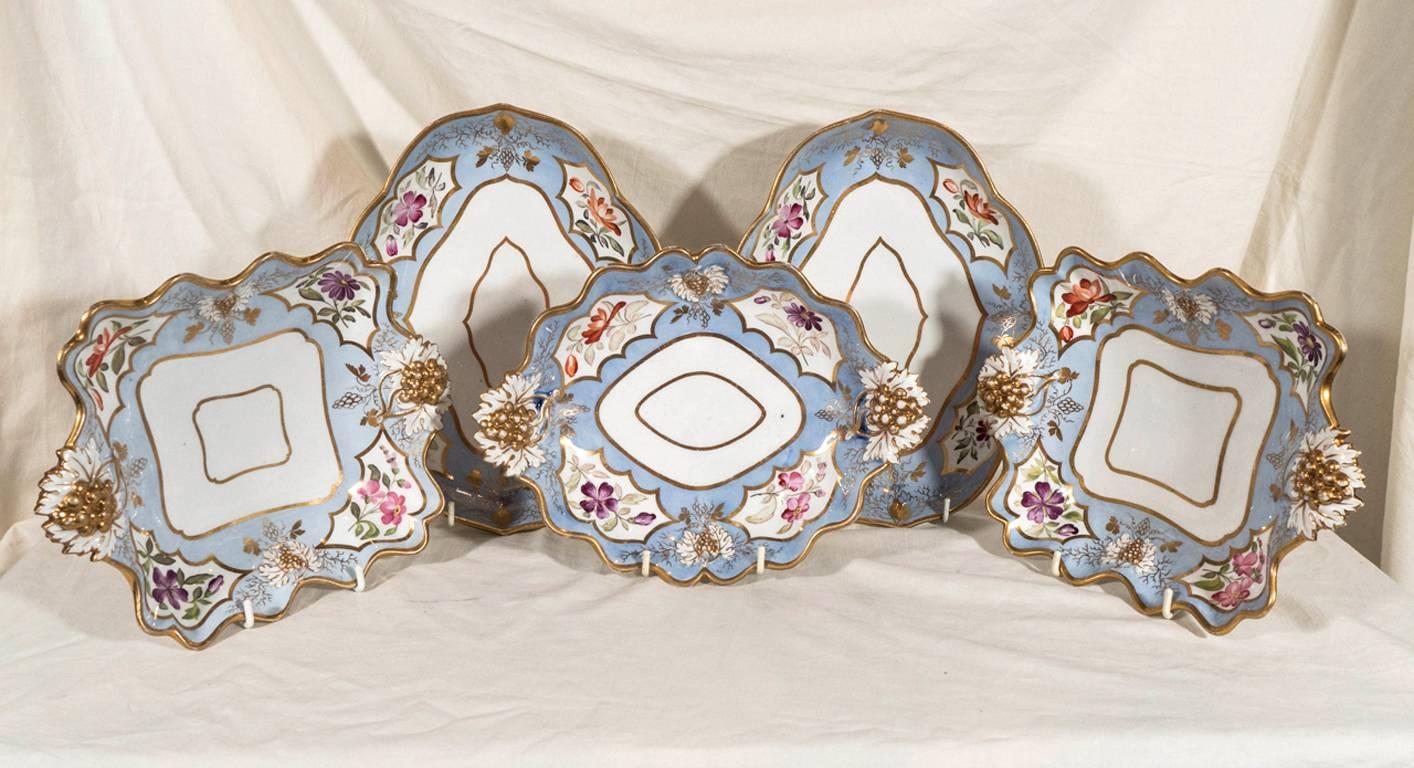 A lovely group of five periwinkle blue Ridgway dishes painted with flowers in soft colors of pink, purple and orange. Some dishes with impressed and gilded grapes on the handles.
In the early Victorian period the unusually shaped dishes in a desert