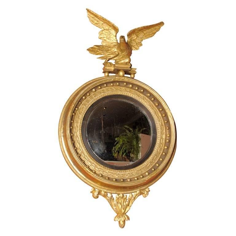 A nicely carved English Regency period convex mirror made in England circa 1810 featuring a great eagle. An elegant carved band of stylized wheat sheaves. Well and deeply carved moldings with lots of small spheres. A separate ebonized reeded filet.