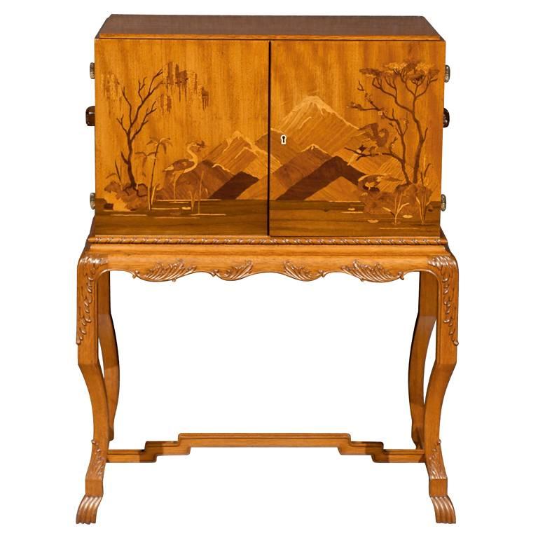 Asian influenced intarsia cabinet of golden elm on a carved cabriole leg base.

Actual color is much softer than what you see in these photographs. Please refer to Image No. 3 for truer color than main image.

Please contact us with any