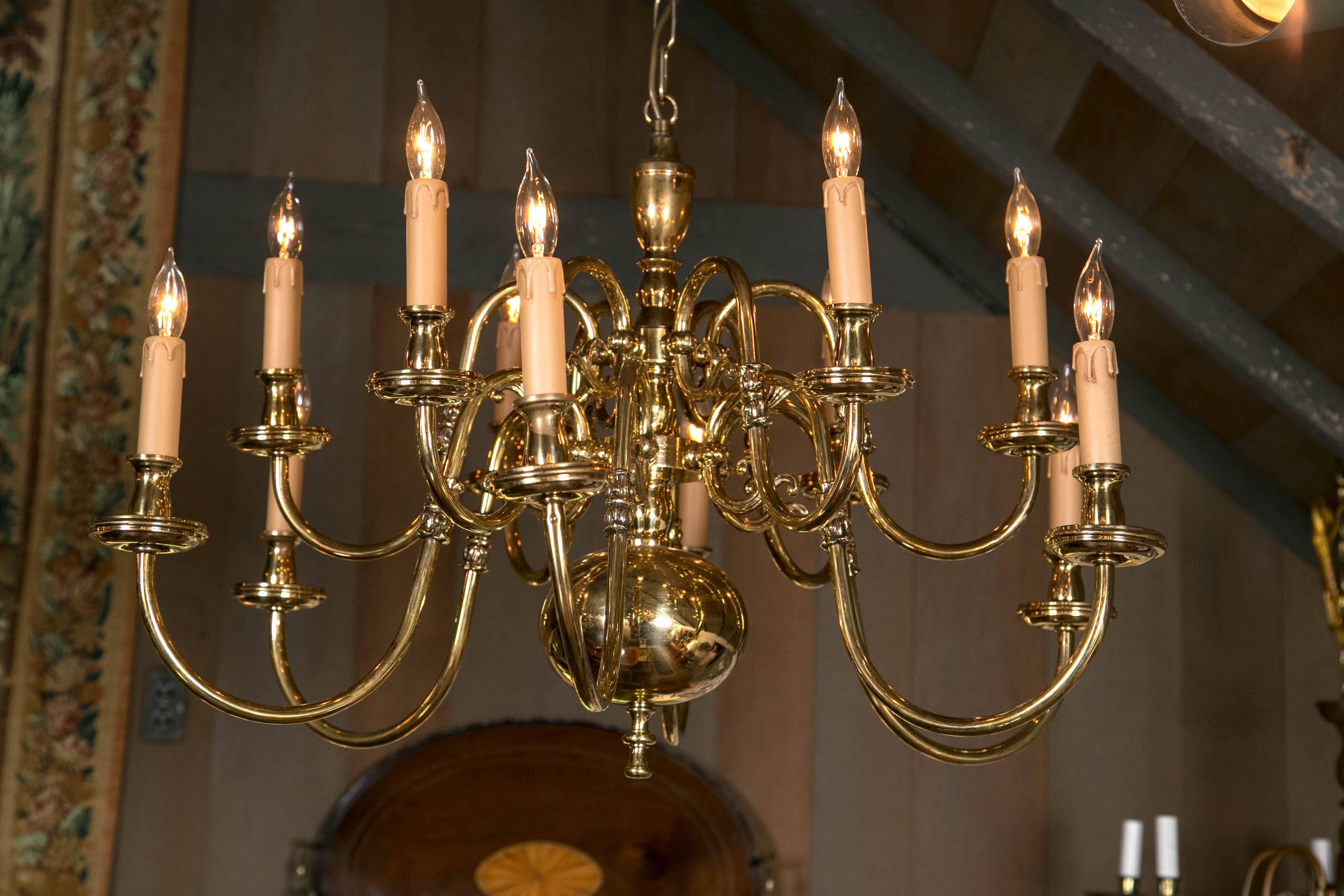 Twelve arms in a six-over-six arrangement and connected to a turned center support create a sparkling array of curves and angles that keep the eye amused as one arm weaves past the next. Polished, lacquered, and electrified, this chandelier is ready