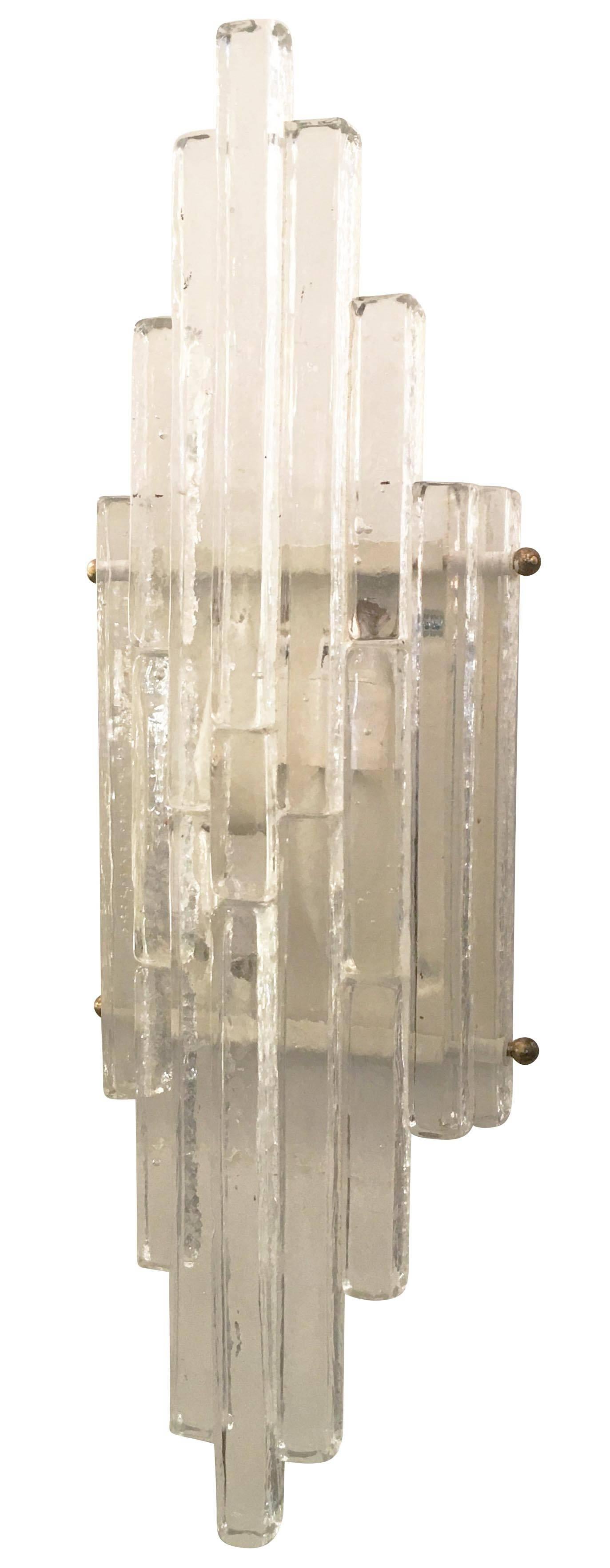 Sculptural pair of sconces by Poliarte composed of interlocking glass rectangles of different sizes. All the glass pieces are clear and are held together by two metal rods which allow for them to lock on to the white painted frames. Each holds two