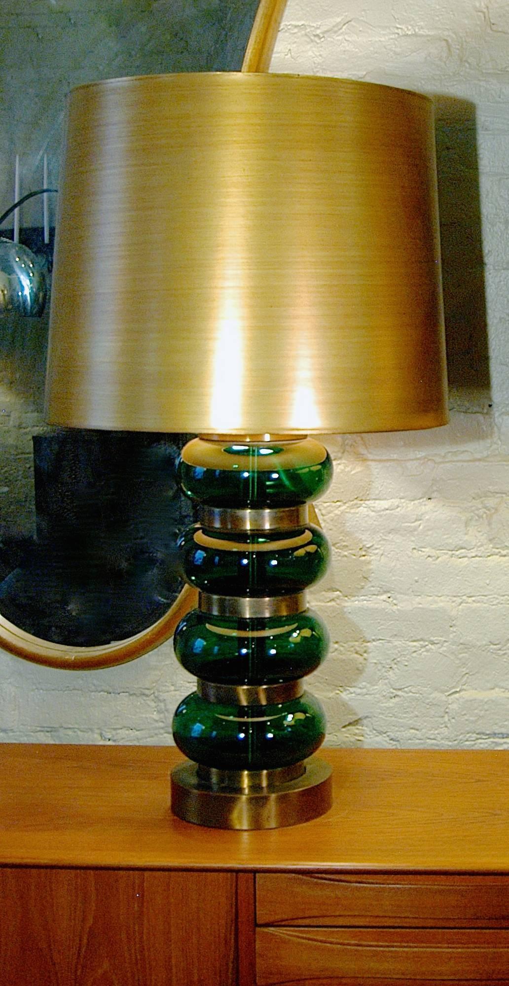 Large, impressive, mid century, table lamp in the Hollywood Regency style by  Paul Hanson. Alternating stacks of brass rings and emerald green glass orbs with original 17