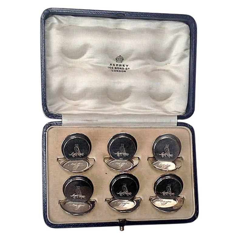 Set of 6 silver place card holders, London 1931, Asprey & Co. Original fitted box. Each of circular disc like form, engraved with the crest of an owl. All fully hallmarked and stamped Asprey London. Measures: 1.25 x 1.0 inches. Total Item Weight: