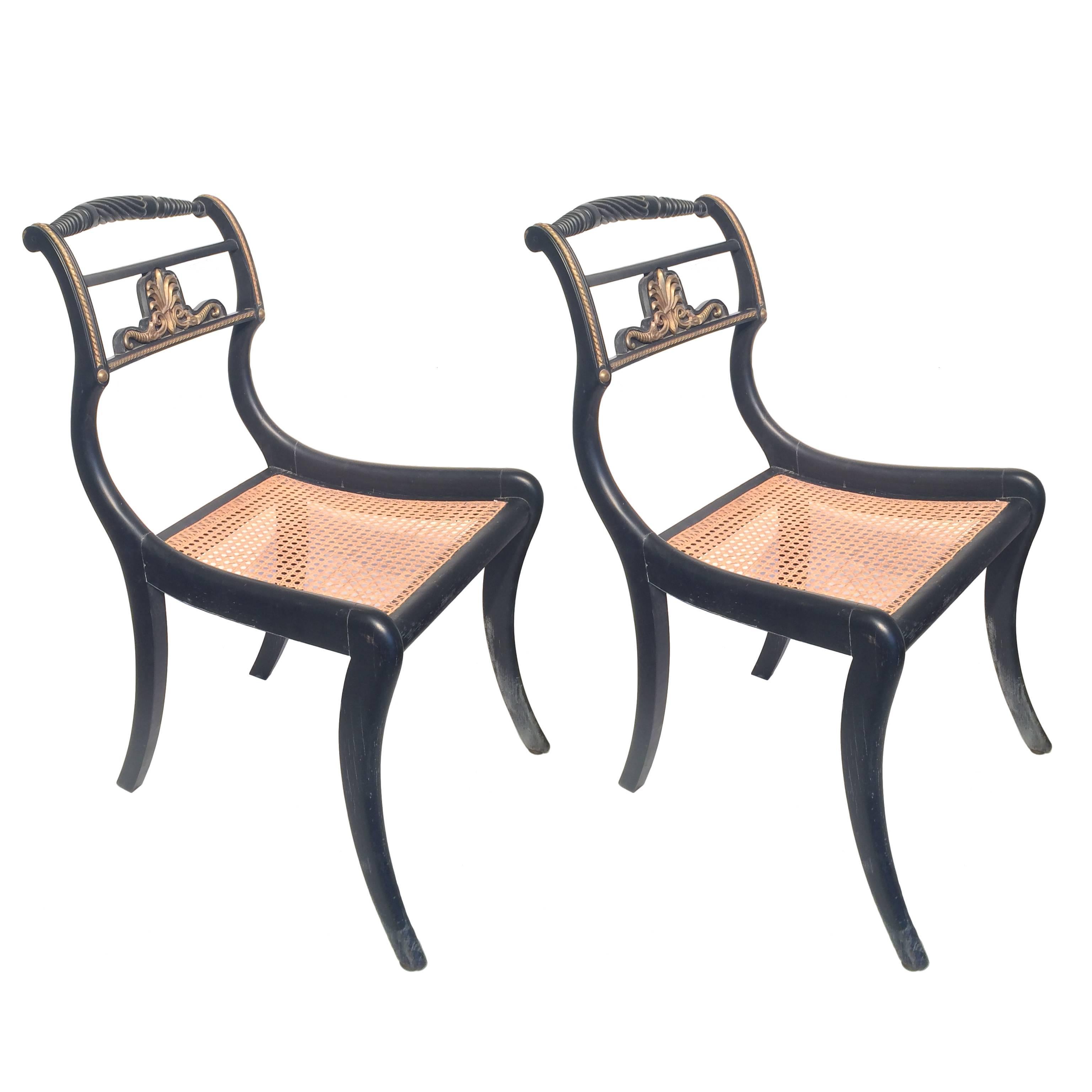 A pair of English Regency period occasional chairs, c. 1810. Ebonized wood, bronze ormolu and caned seats.