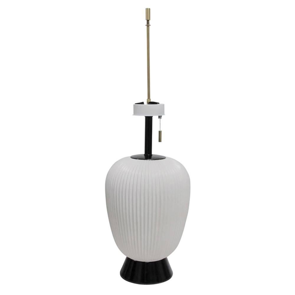 Gerald Thurston table lamp for lightolier in white porcelain, USA, 1950s. Japanese lantern form fluted porcelain lamp by Gerald Thurston for Lightolier. Mounted on a painted black aluminum base. Rewired and with new sockets for immediate use. Cloth