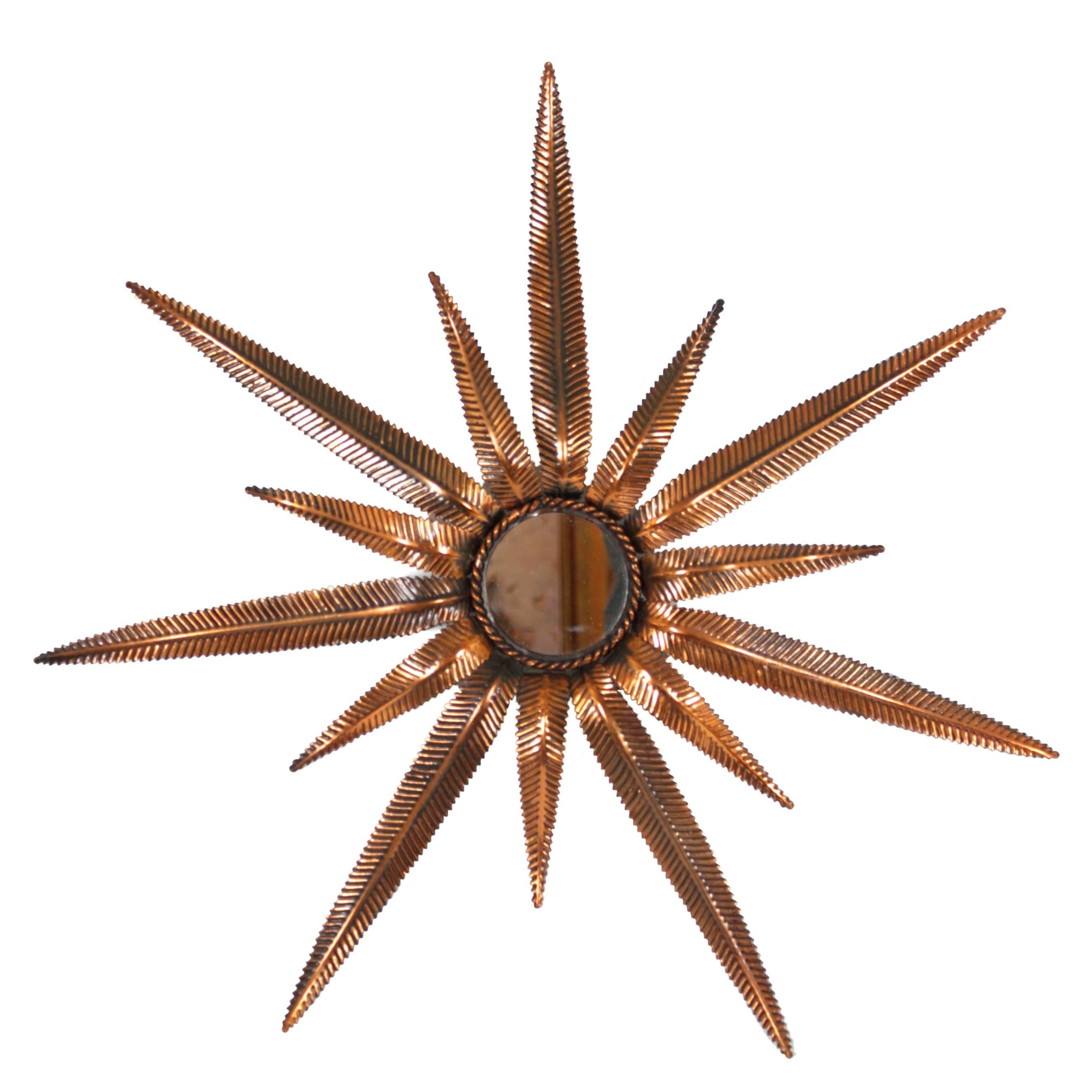 Unusual sculptural starburst mirror made in copper with two size of leaves. Each leave has an engraved decoration. Gorgeous original patina.
Made in Spain, circa 1950.

More sunburst mirrors and other kind of mirrors are available.
Please kindly