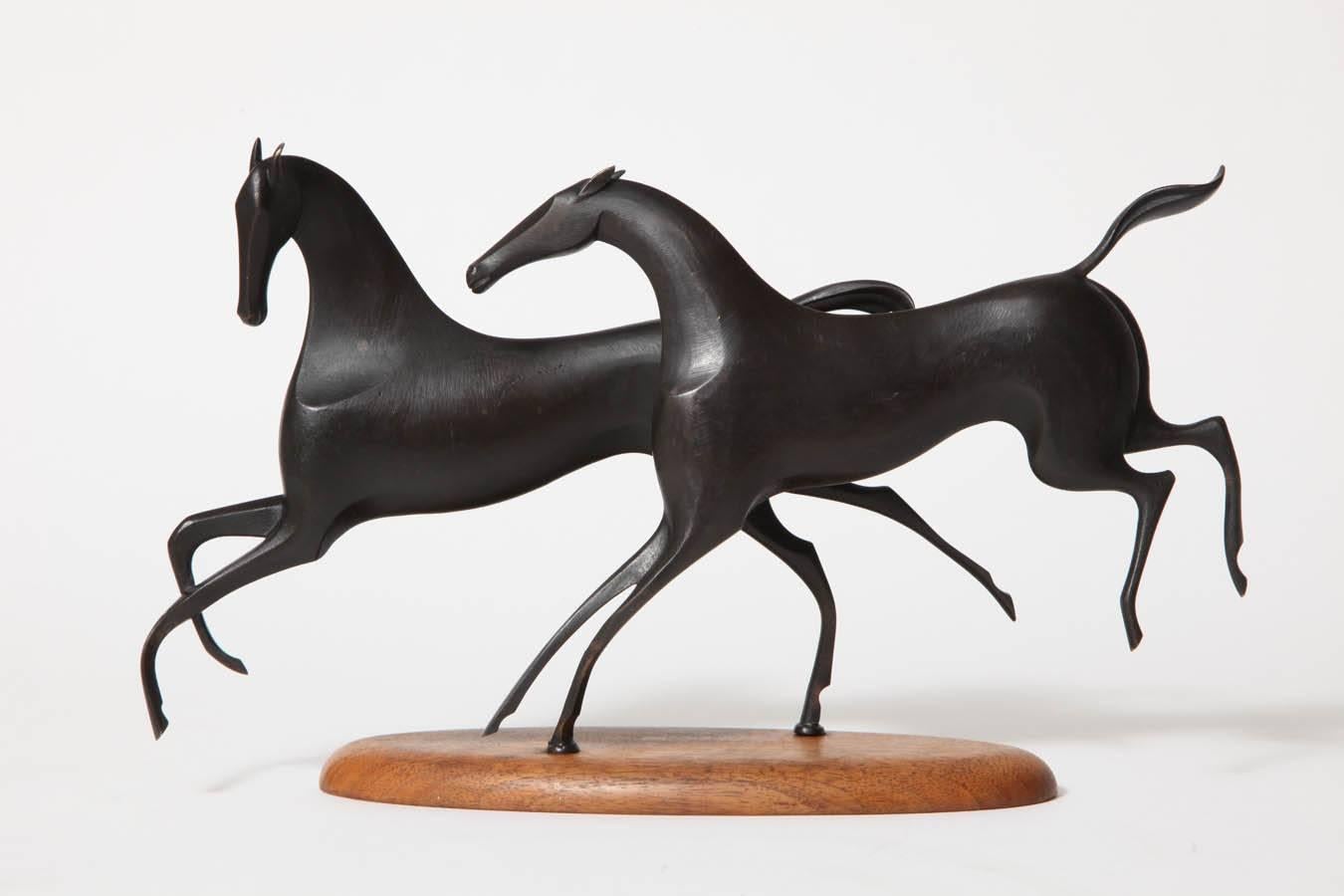 A pair of Karl Hagenauer prancing horses. Black patinated bronze Horses on an oval wood base, Mint condition, circa 1950. Marked on underside of wooden oval base, WHW (Werkstätte Hagenauer Wien), Made in Austria, Handmade.