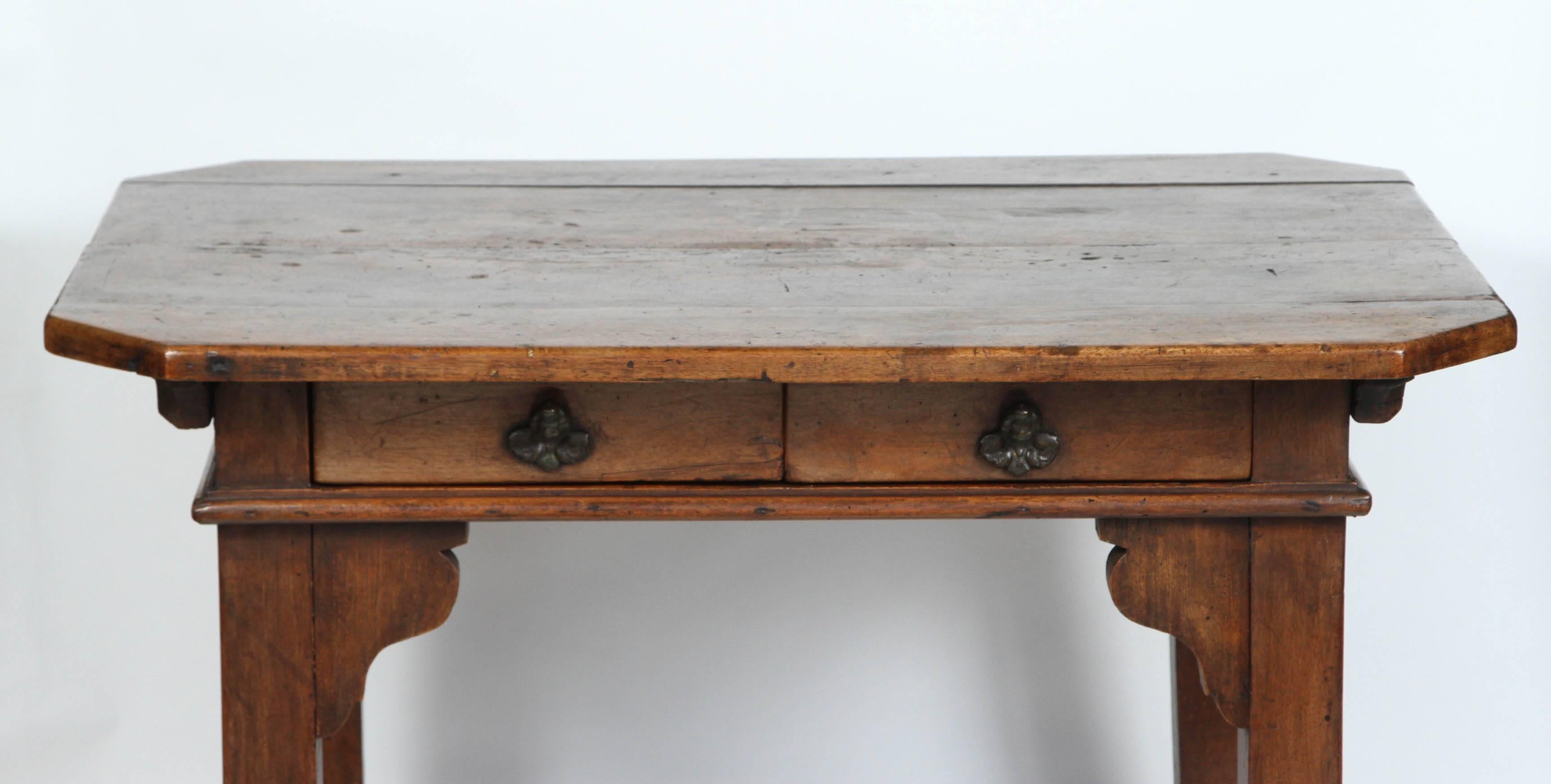 An 18th century Spanish walnut stretchered table with two drawers, circa 1770. The patina is rich and luminous. The drawer hardware are charming putti heads.  This piece can serve as an excellent side table, sofa table or console.