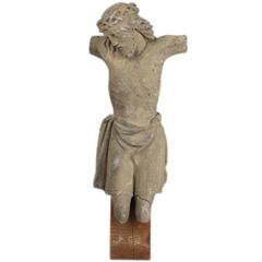 Sculpture en pierre calcaire ancienne de style médiéval représentant le Christ en forme de crucifix