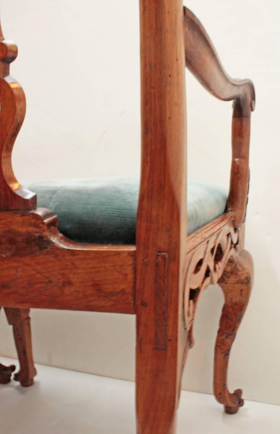 A carved walnut chair back settee with open work splats and apron, six carved cabriole legs in front, pegged construction, upholstered in blue velvet,

Continental, possibly Dutch.

Walnut bench in George II taste.