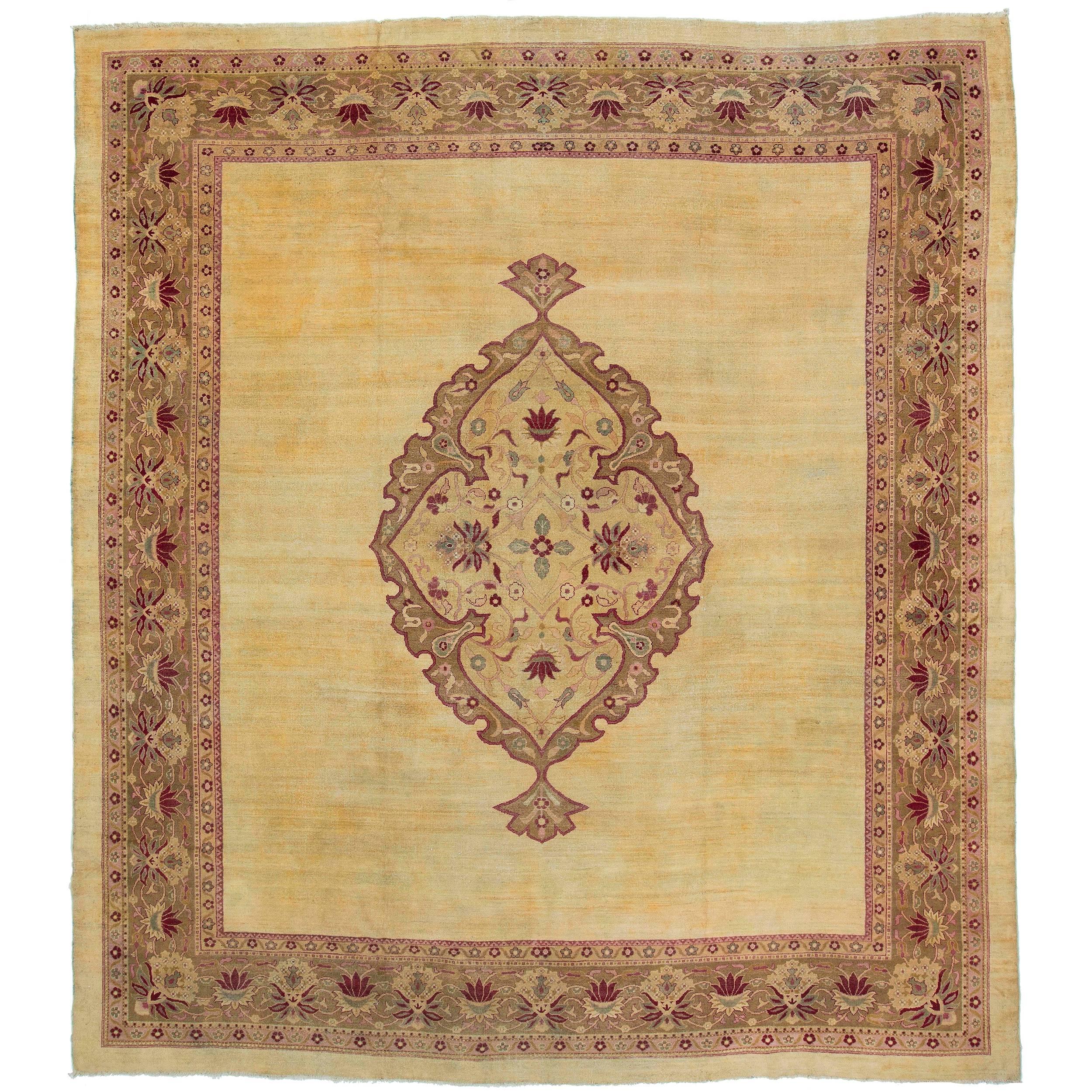 A dramatic and regal style Amritsar carpet from the northern Indian city. A gentle saffron background amplifies the use of burgundy reds and pinks drawn in Safavid influenced medallion. Measures: 13'10