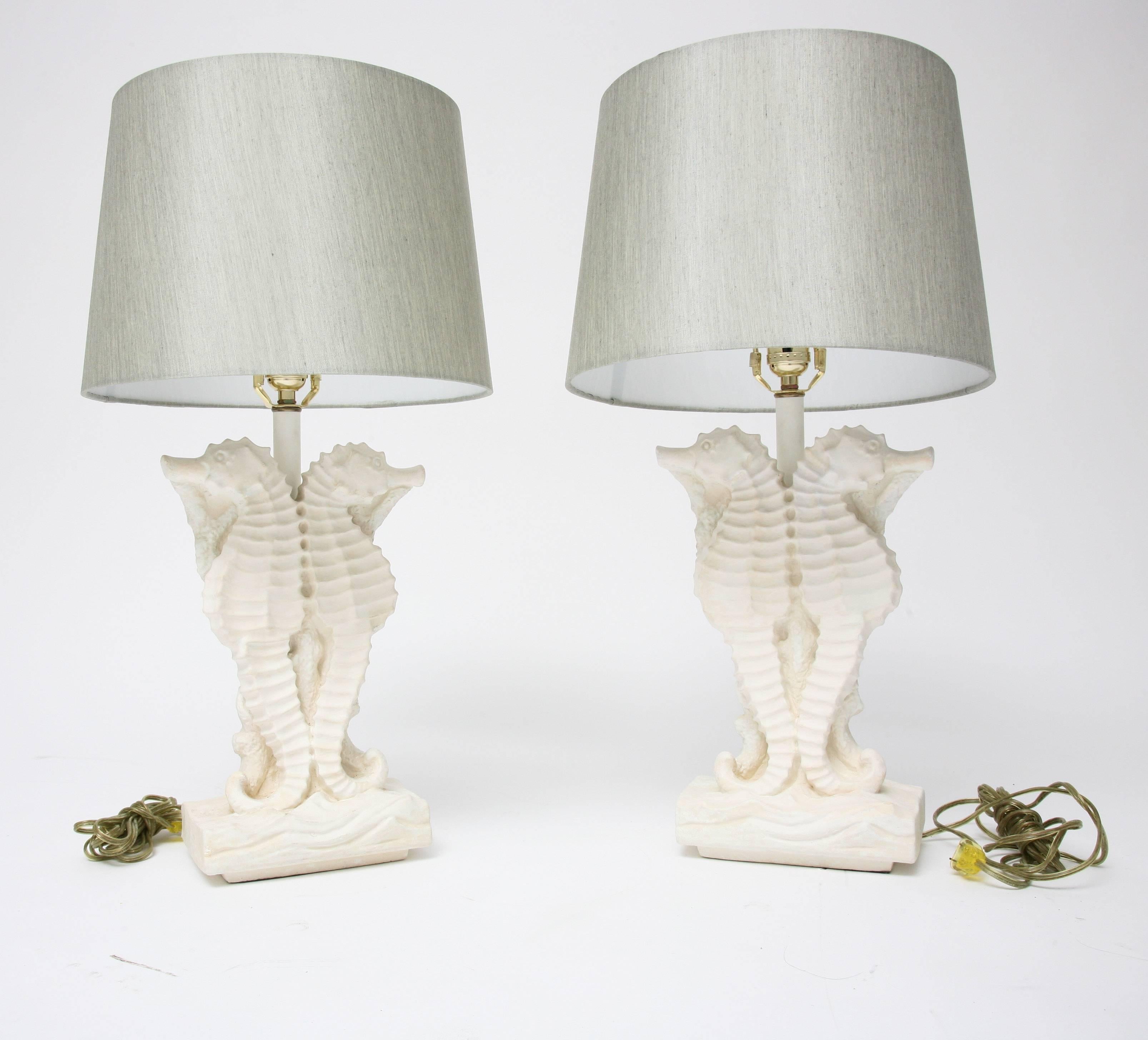 This pair of stylish sea horse motif table lamps are of molded plaster in a painted off-white-bone coloration with a soft-sage-green colored, faux-silk, hard-back shade. 

Note: Dimensions of (sea horses) base are 13.25" x 8.50" x