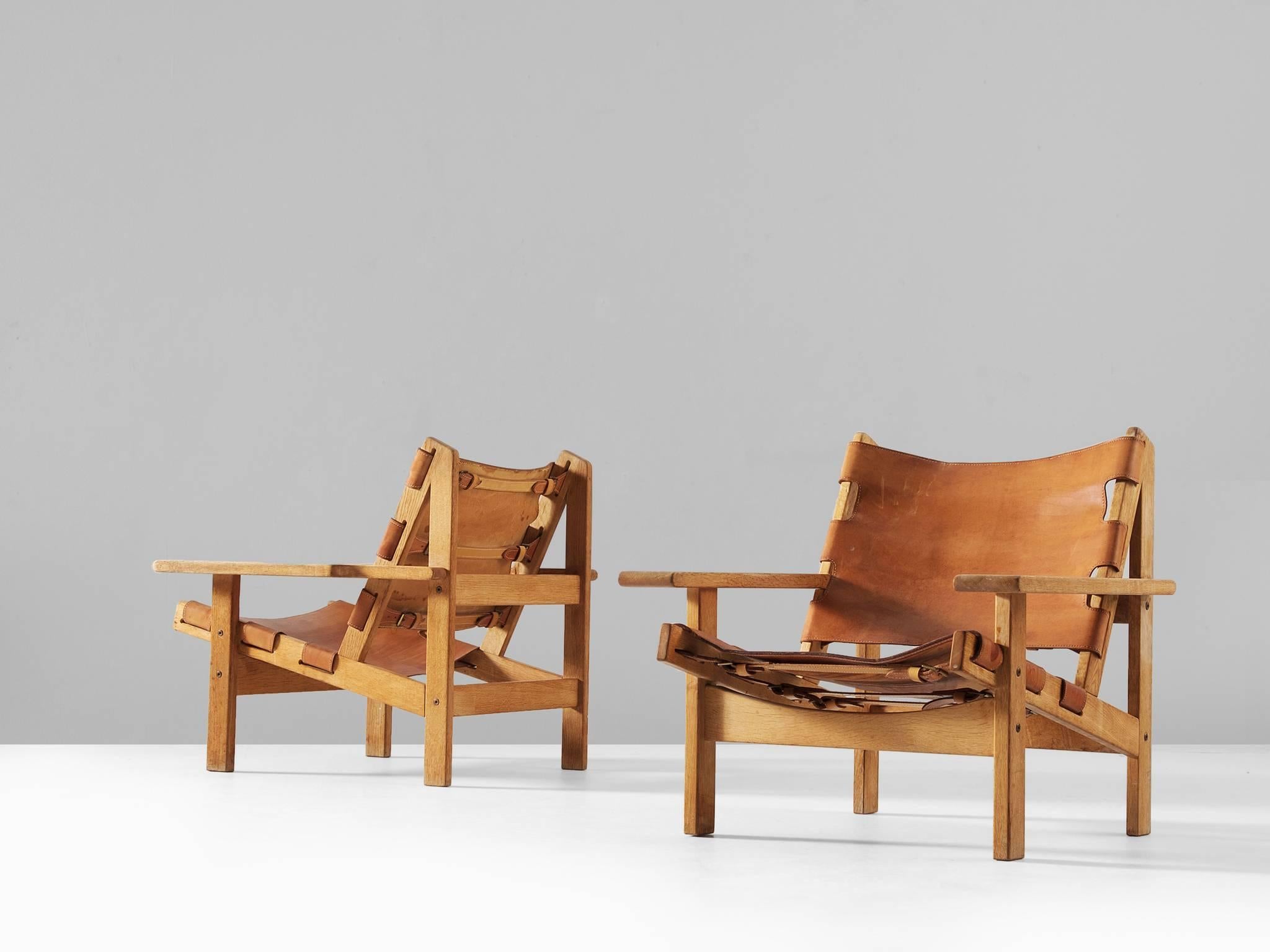 Pair of hunting chairs, in oak and leather, by Erling Jessen, Denmark, 1960s. 

Stunning pair of 'Jagt Stolen' by Erling Jessen, who was inspired by Børge Mogensens Spanish Chair. The frame consist of solid oak and makes a sturdy appearance. The