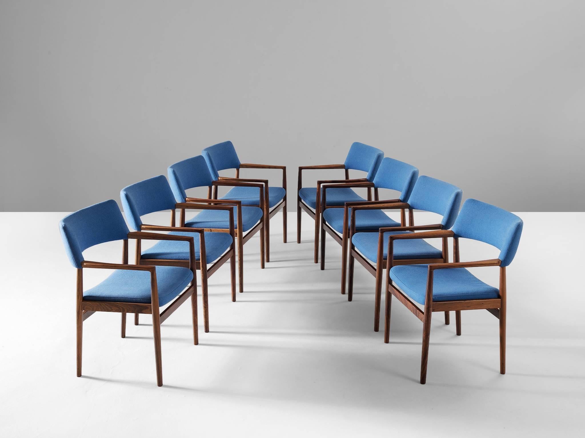 Set of Eight dining chairs, in rosewood an fabric, Scandinavian 1960s.

Beautiful set of eight armchairs with stunning blue upholstery and rosewood frame. These elegant chairs have a simplistic design with straight lines and some subtle curves.