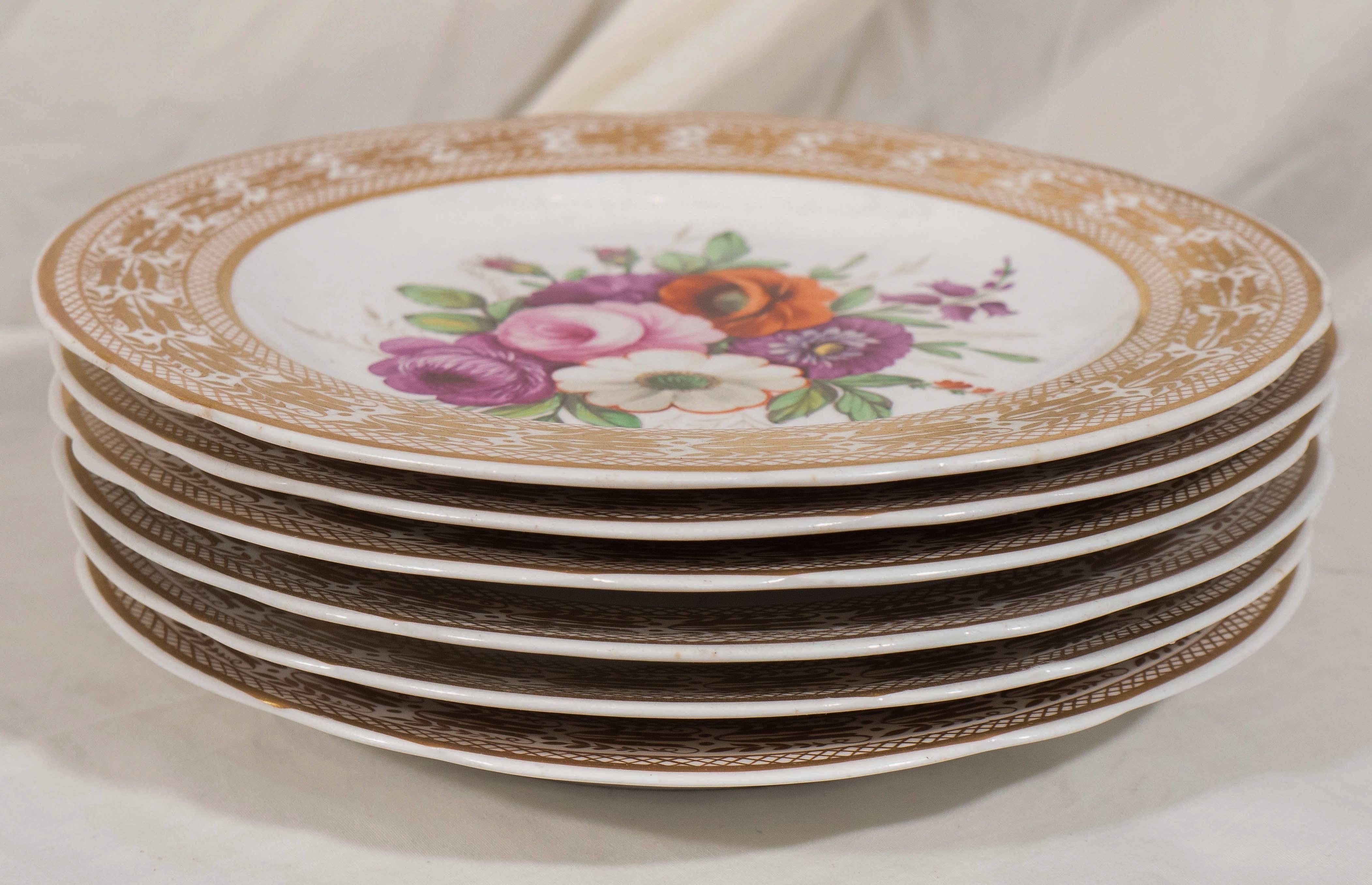 Each dish is hand-painted with a large bouquet of beautifully painted flowers. The bouquets are framed by a wide gold border decorated with stylized tulips and cross hatching.