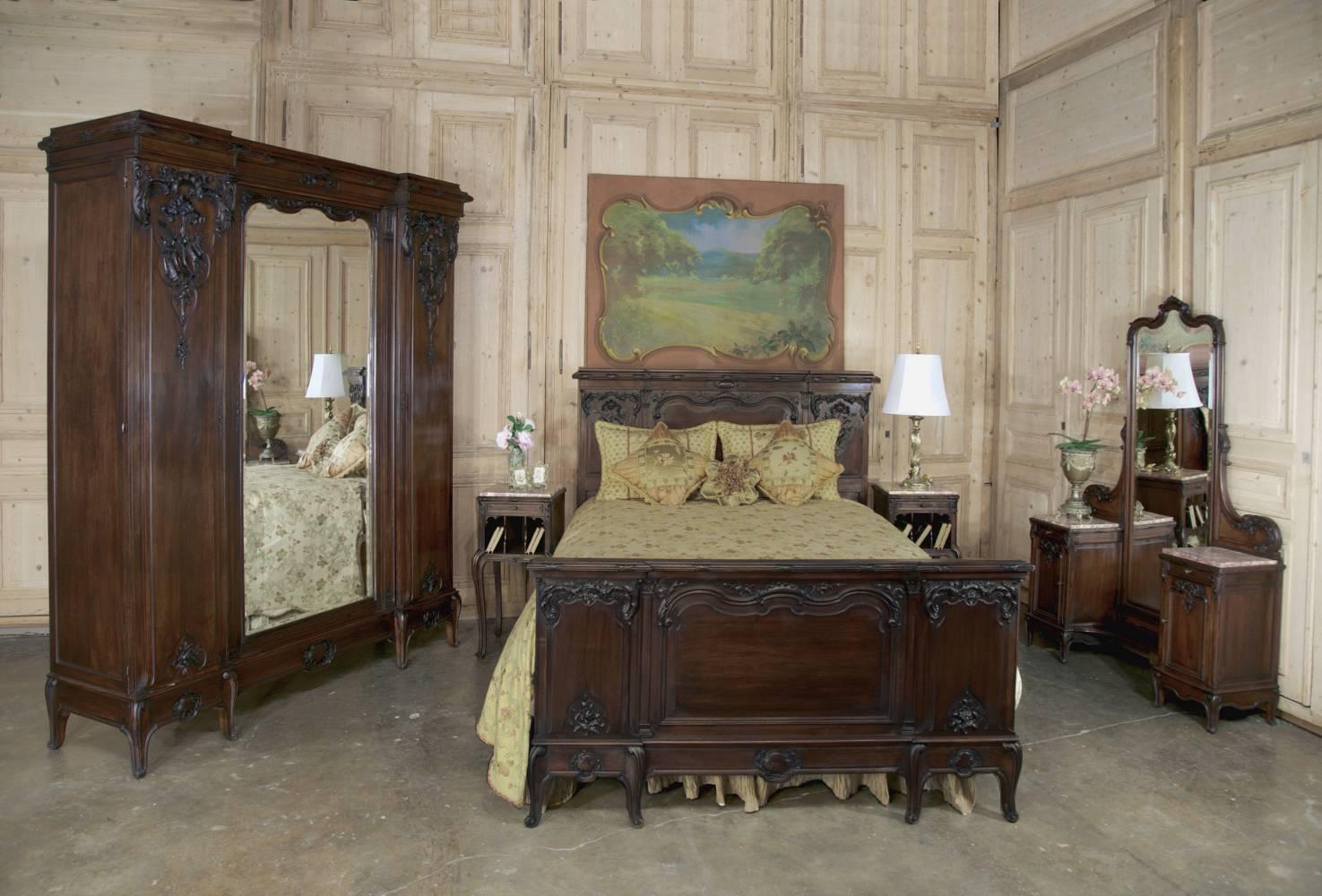 Stunning 19th century French walnut neoclassical bedroom set includes a stately triple armoire, a Queen bed ~ a pair of marble top nightstands and a dresser/vanity with full length dressing mirror and two marble top cabinets! Proudly hand-crafted by