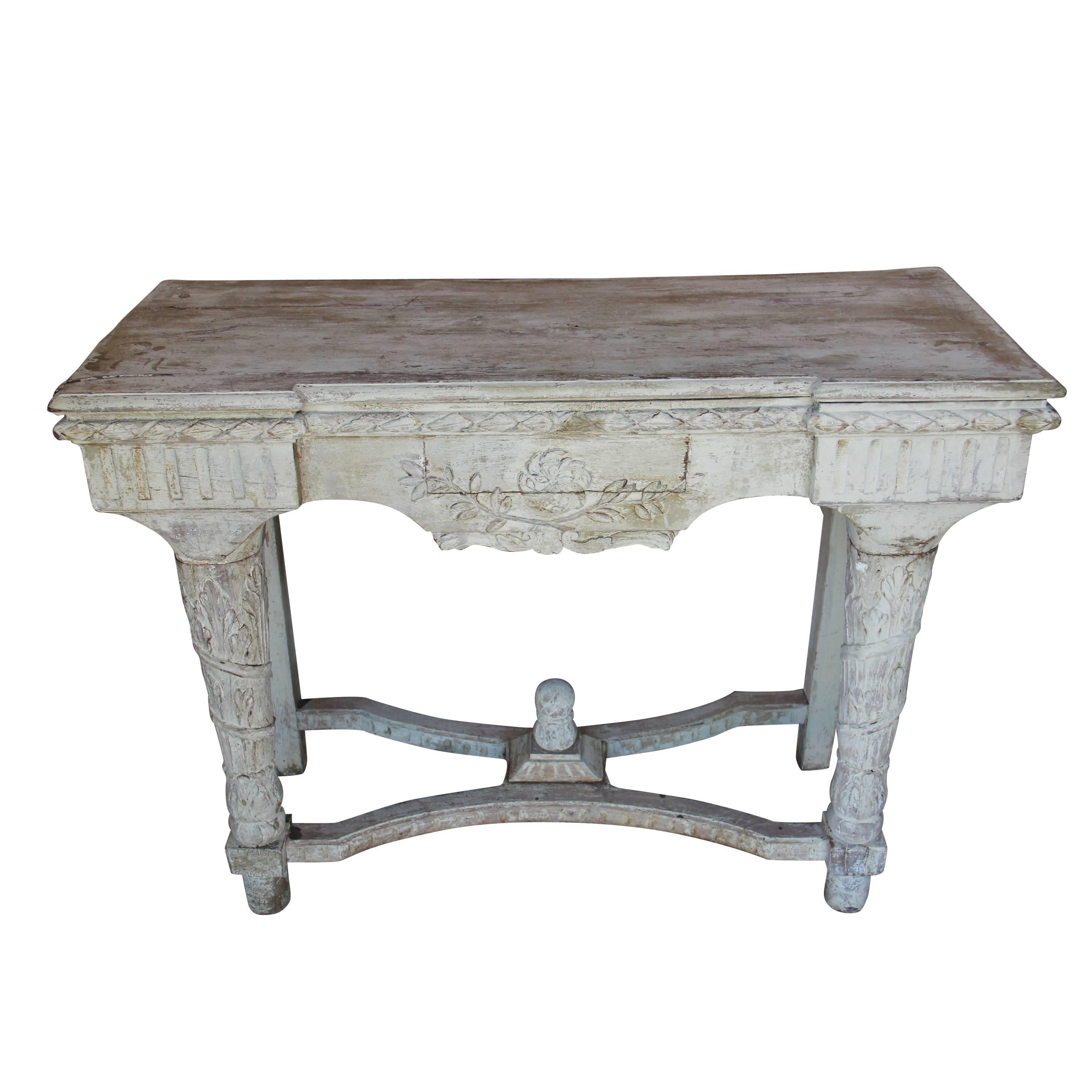 A richly carved French Louis XVI style console table in original cream colored paint from the 19th century. The patina on this piece is amazing. Found in the south of France.