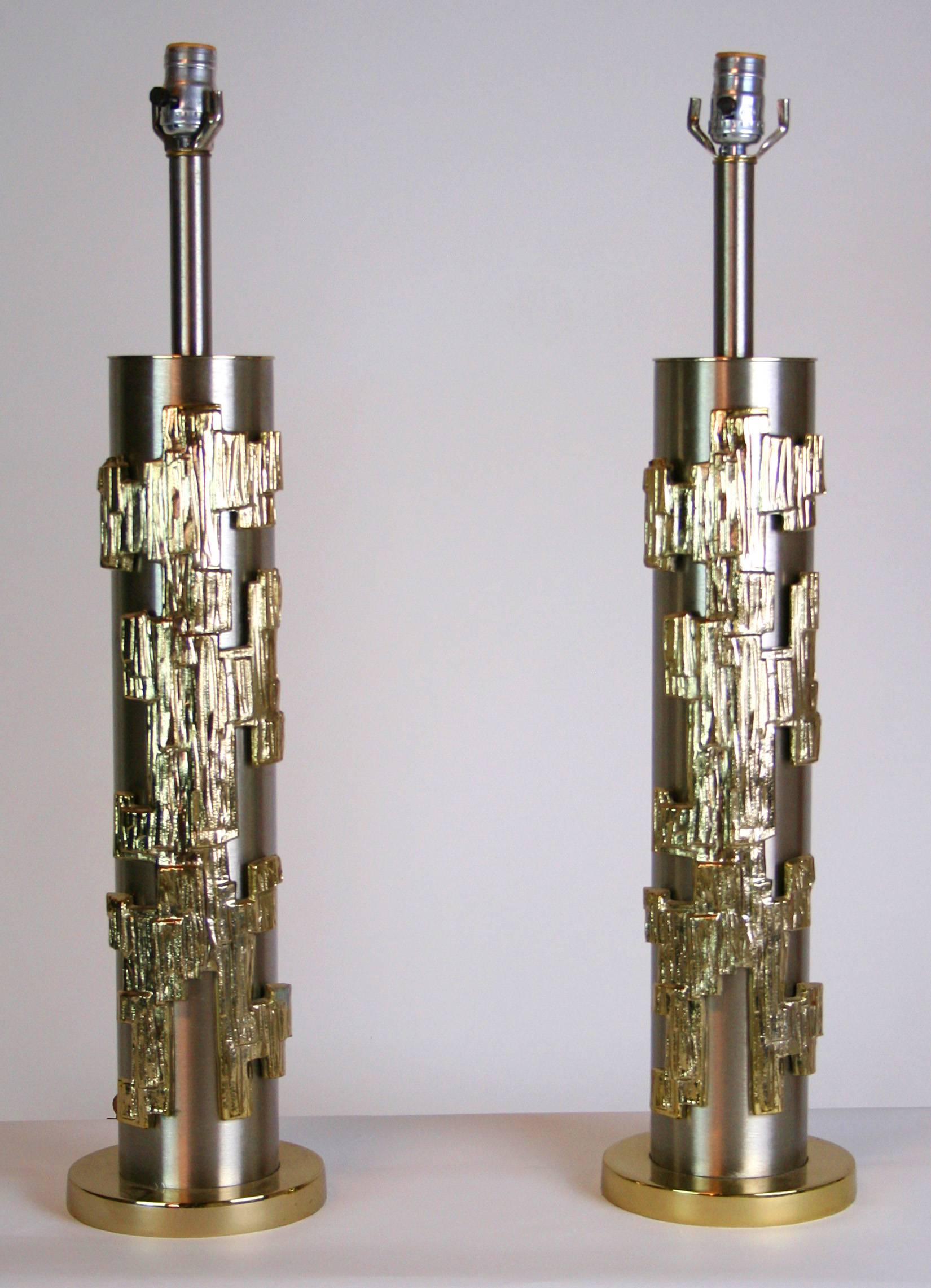 Chic pair of stainless steel cylinder lamps with applied abstract brass decoration, measures Shaft 4