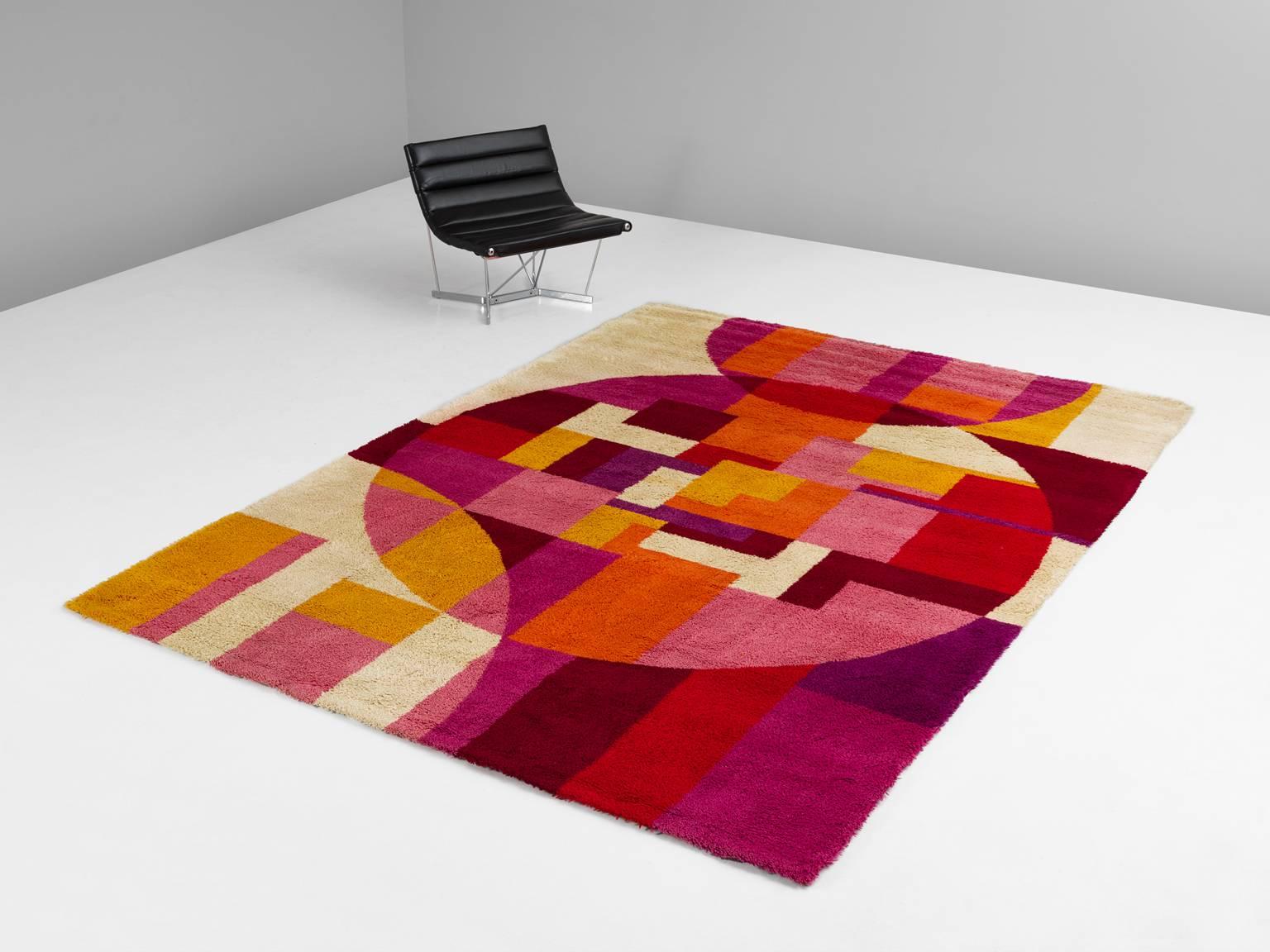 Carpet, in wool, Europe, 1970s.

Graphical and colorful rug from the 1970s. This tufted rug shows a nice combination of geometrical shapes and bright colors. Several shades of pink, red, yellow and orange are combined with an off-white back