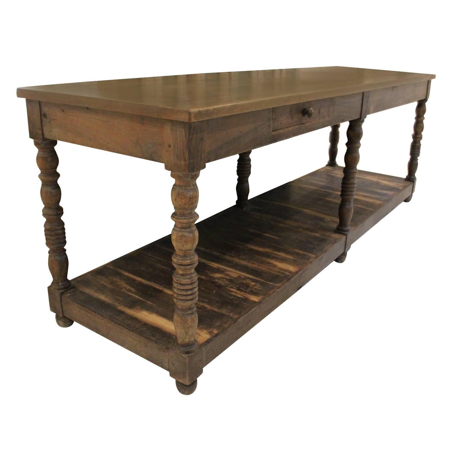 A French draper's table with pot board in walnut wood with a rich, time-worn patina. This beautiful table with single drawer and turned legs would make a wonderful kitchen island, console, serving table, or display table for a restaurant or store.