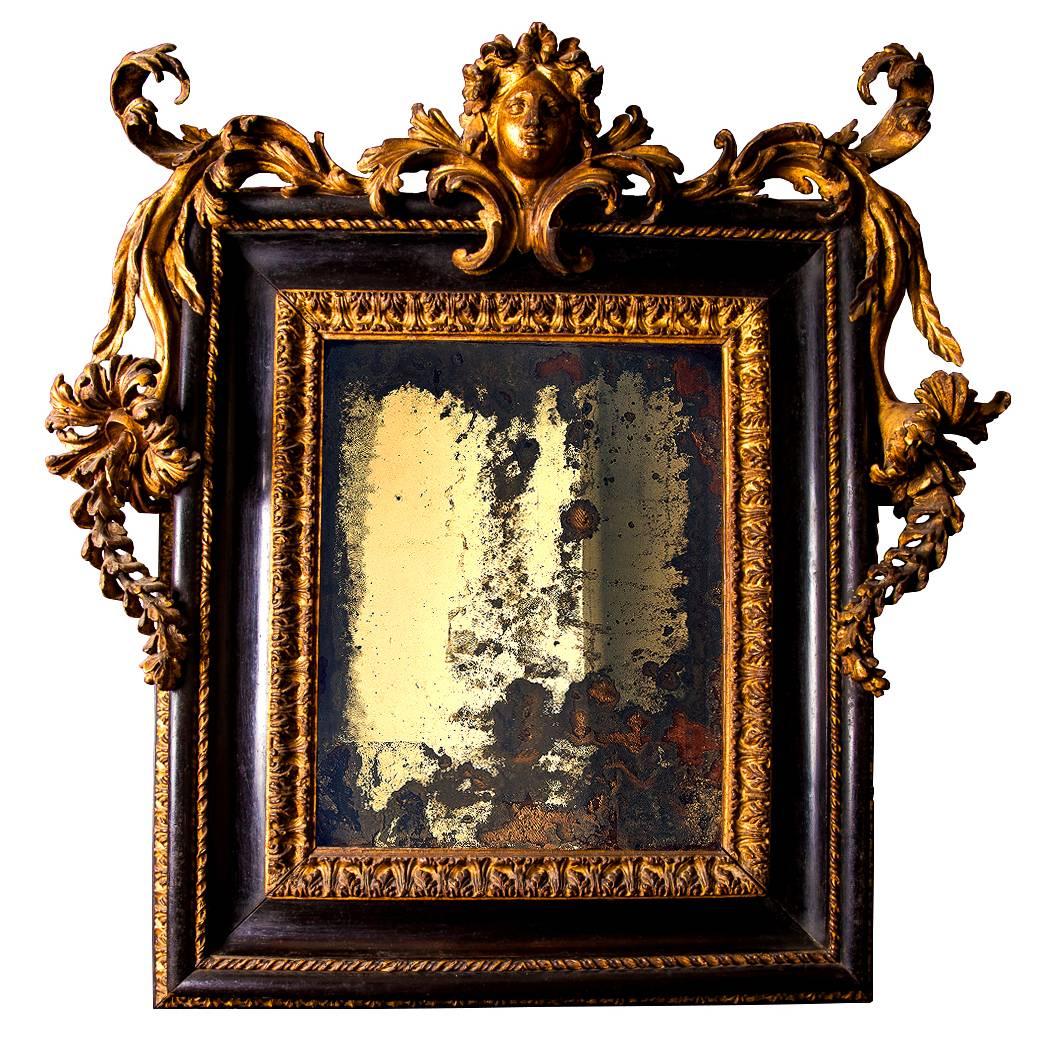 Baroque Italian carved giltwood and ebonised mirror Roman, late 17th century