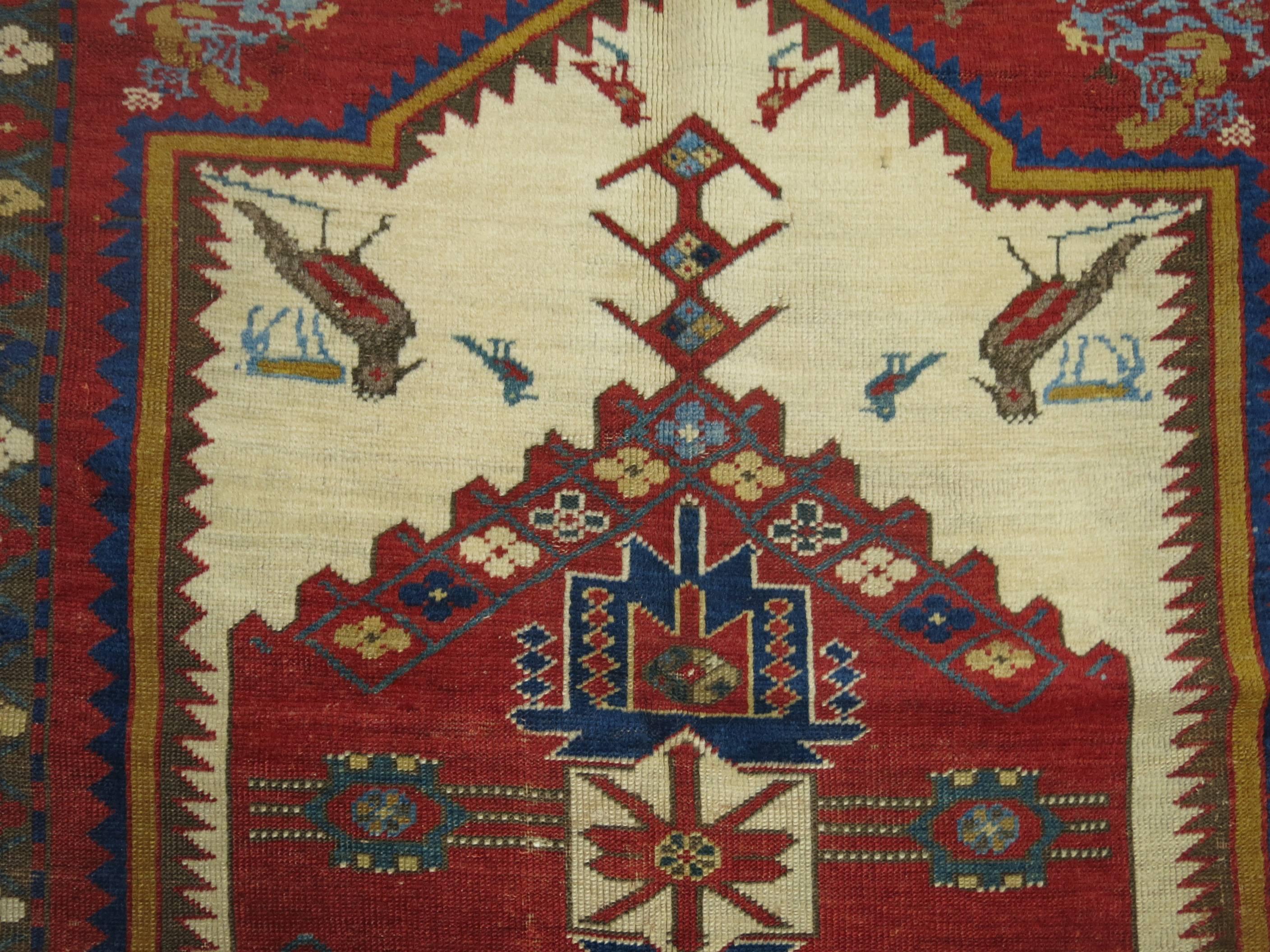 A beautiful intermediate size antique Caucasian Kazak rug featuring a set of birds with predominant accents in vivid reds, ivory, forest green and ivory. Very finely woven,

circa 1890. Measures: 4'4