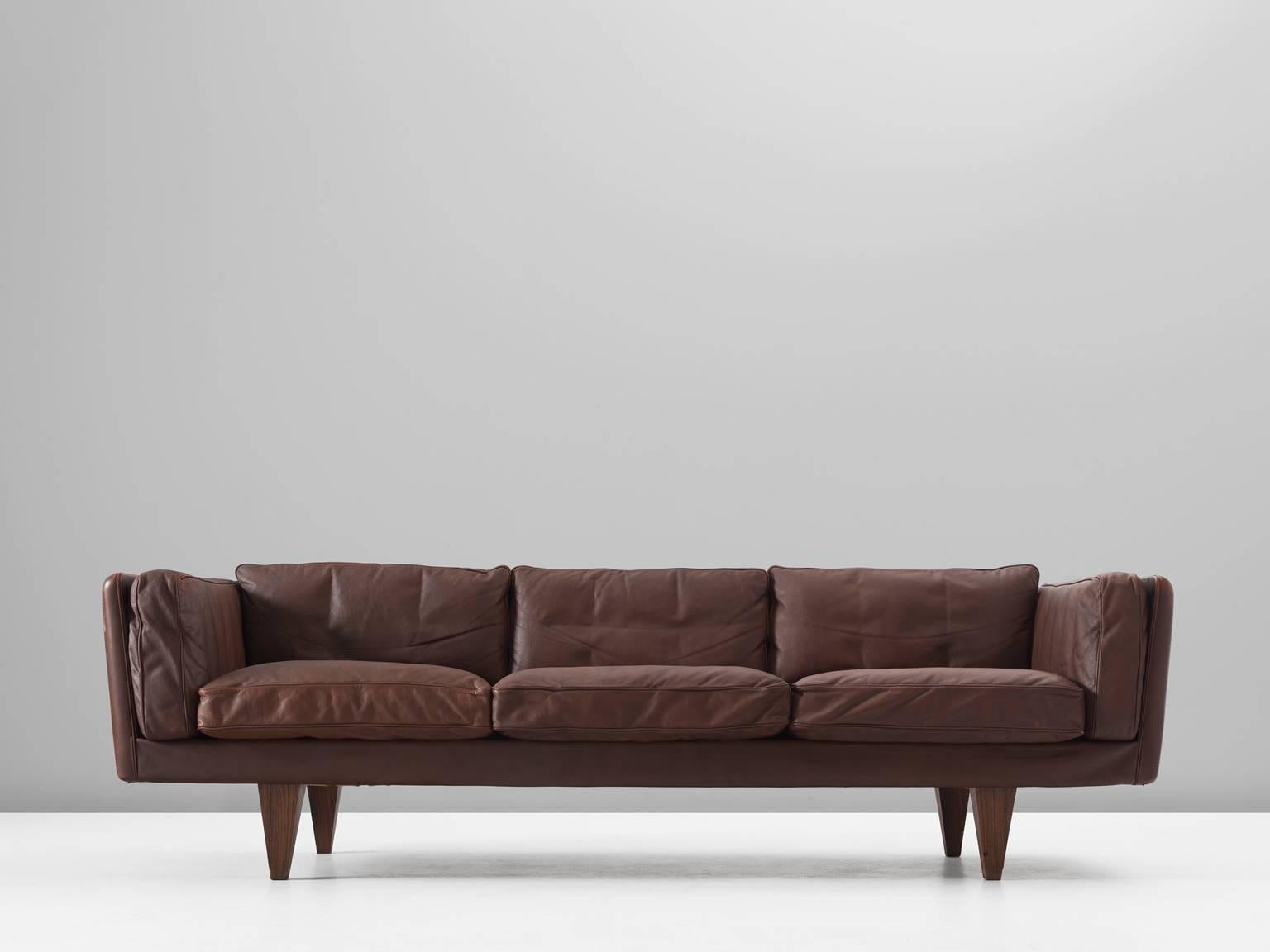 Sofa model V11 in leather and rosewood by Illum Wikkelso, Denmark 1960s. 

Stunningly three-seat sofa, designed by Danish designer Illum Wikkelsø. Highly comfortable and beautiful designed sofa with original upholstery. The brown high-quality