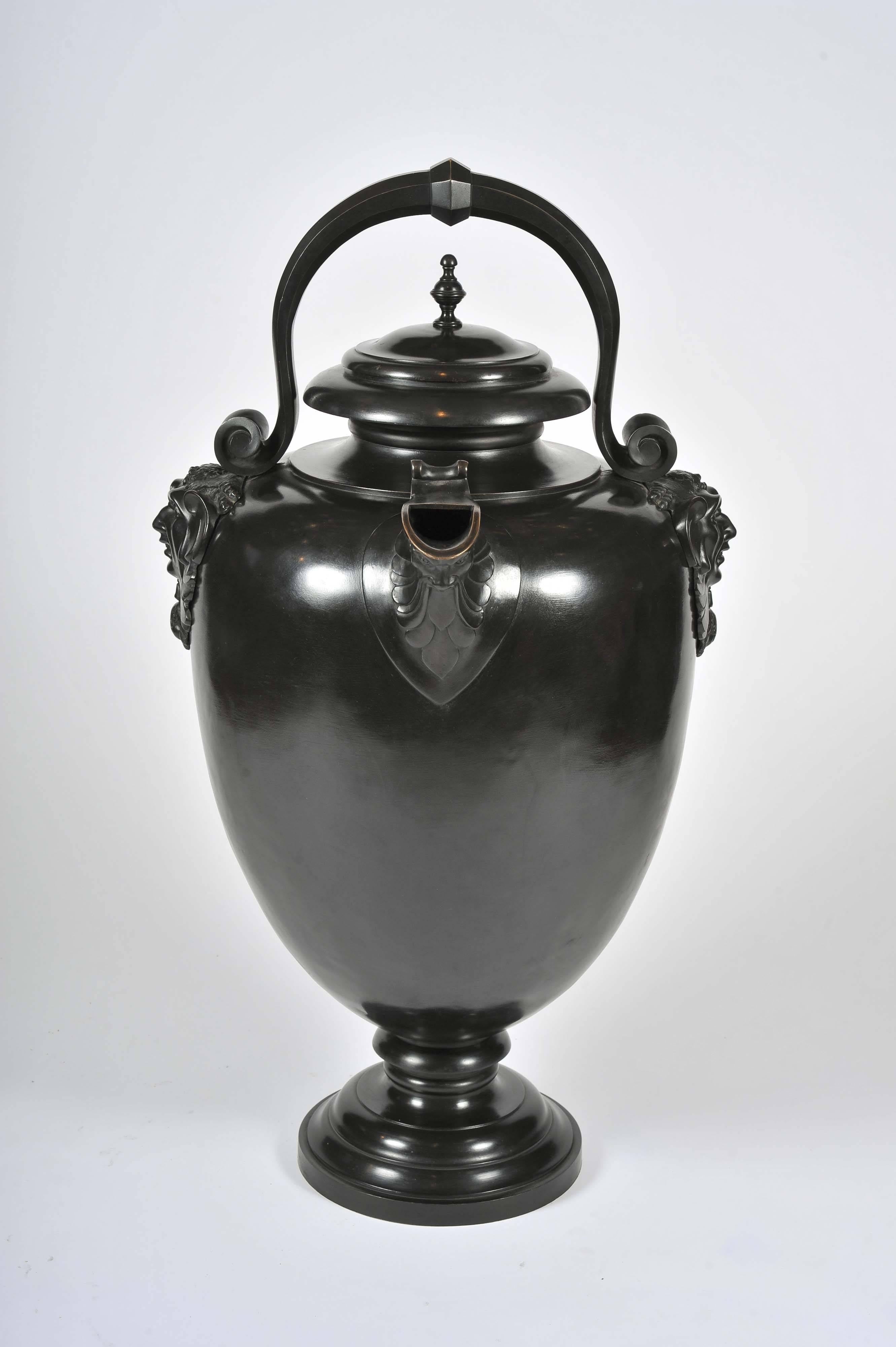 A magnificent bronze urn and lid with scroll handle and spout supported by 