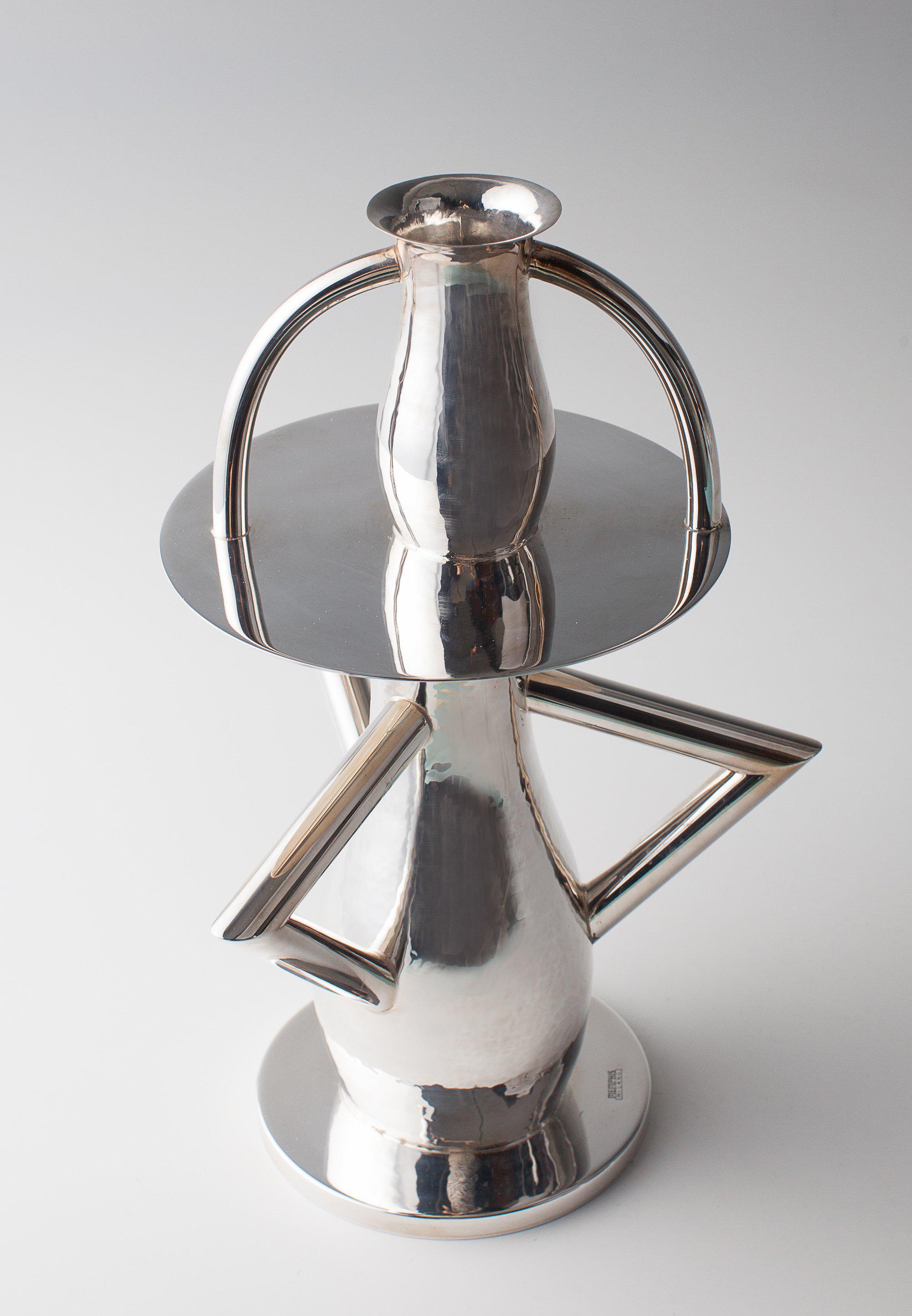 The Alaska is a flower vase in silver brass.
It is one of the first designs produced by Sottsass for Memphis in 1982.
Measures: H. 30 cm.
Executed by Rossi e Arcandi, Monticello Conte Otto, Vicenza for Memphis, Milan. Brass, asymmetric several