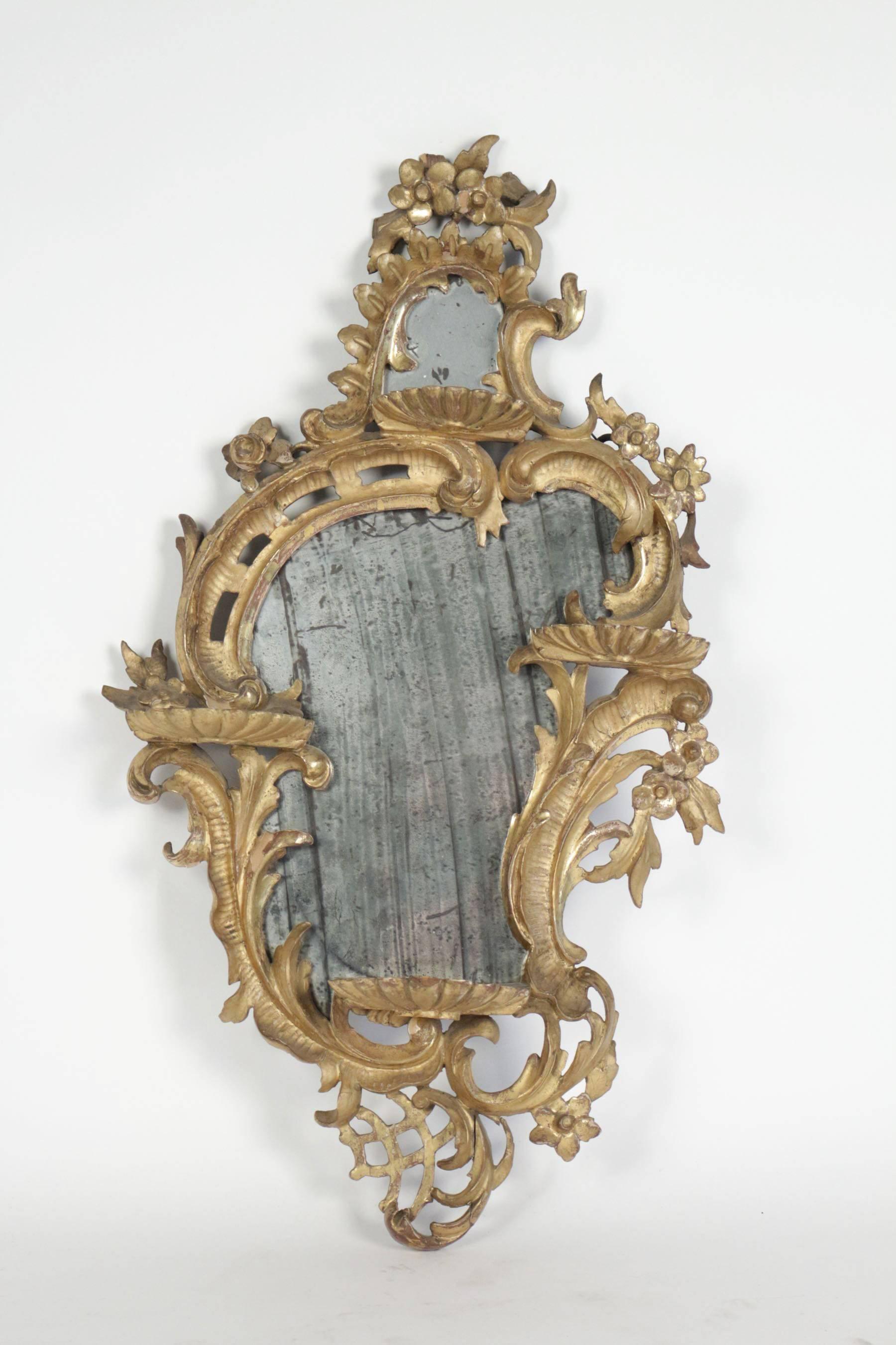 Lovely and very fine quality Italian original giltwood small mirror, richly hand-carved and decorated with openwork scrolling, shells and flowers.
Original mercury glass.

Italian work early 19th century in the classical Louis XV