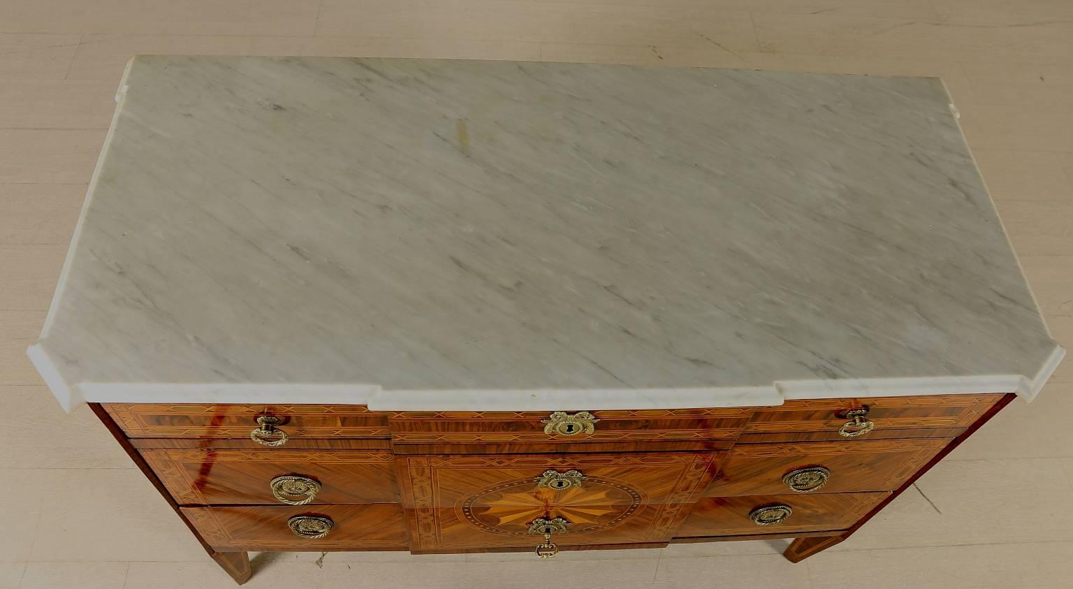 A late 18th century neoclassical Italian walnut and rosewood veneered inlaid chest of drawers with 45° uprights. Pair of drawers with central rose decoration and a smaller drawer underneath the top. Shaped carrara marble top. Walnut panels, various