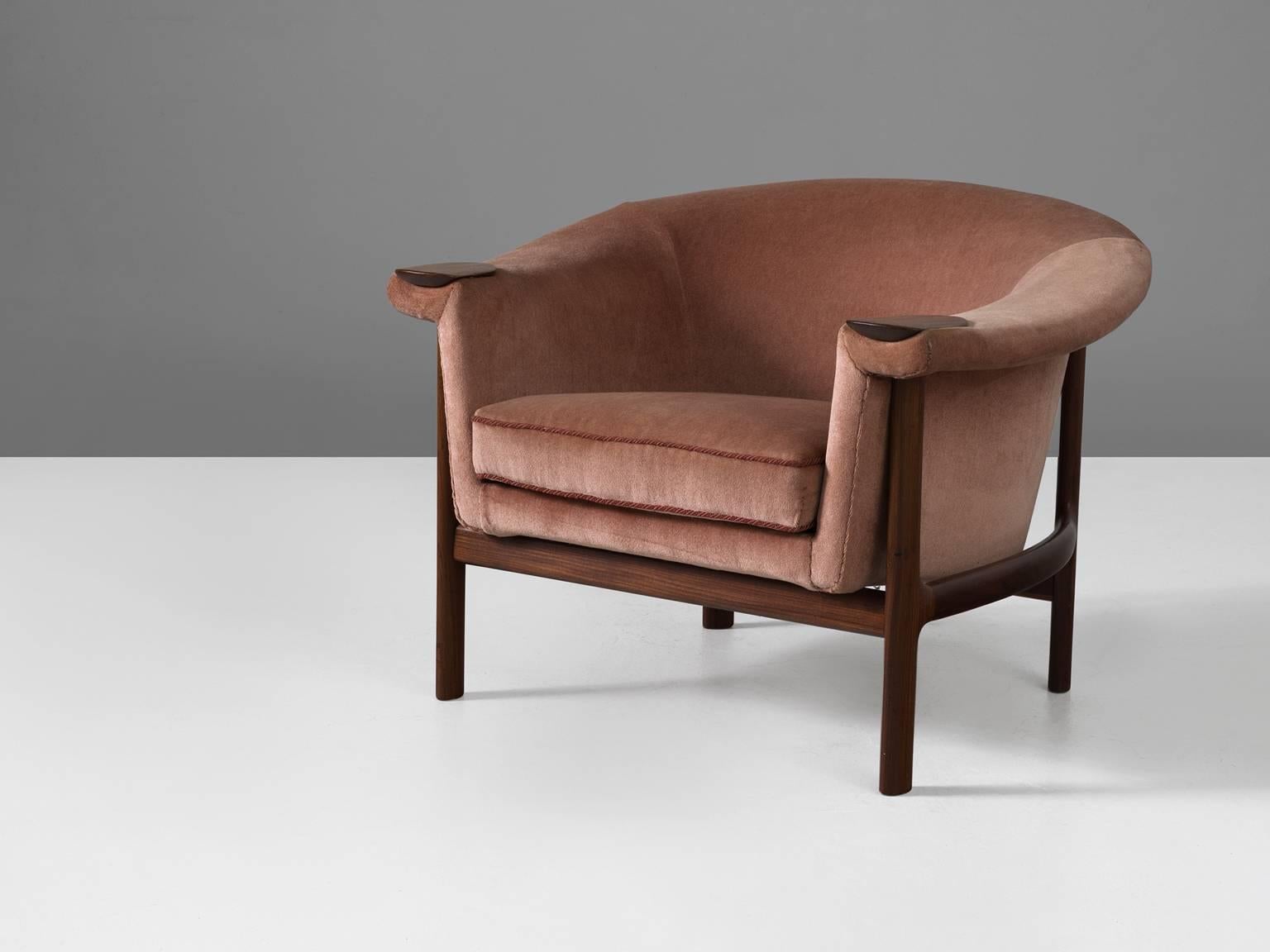 Lounge chair, in wood and fabric by Johannes Andersen, Denmark, 1950s.

Easy chair with a frame of wood and rose mohair-velours upholstery. By the round shapes and soft pink upholstery this chair gets a very soft and appealing expression. The wooden