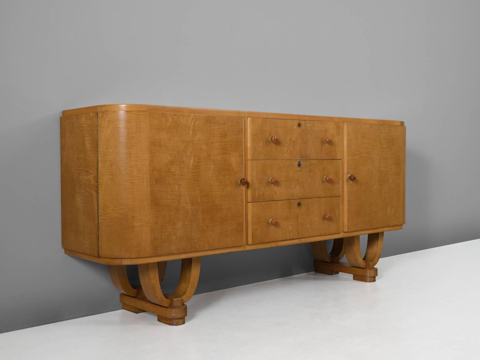 Credenza, in maple and mahogany, Belgium, 1930s.

Very elegant Art Deco credenza. Most remarkable are the legs of this cabinet. Two large U-shaped legs are combined on a rectangular base. The legs are nicely layered and create an floating