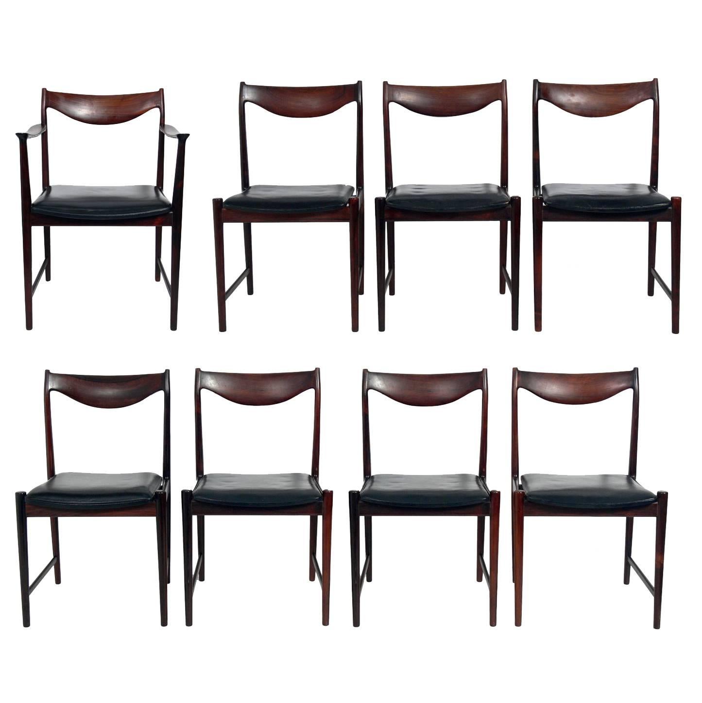 Set of Eight Danish Modern Rosewood Dining Chairs designed by Torbjorn Afdal for Nesjestranda Mobelfabrik, Norway, circa 1960s. Incredible graining to the rosewood. They have been reupholstered in a low maintenance leather like black vinyl. 