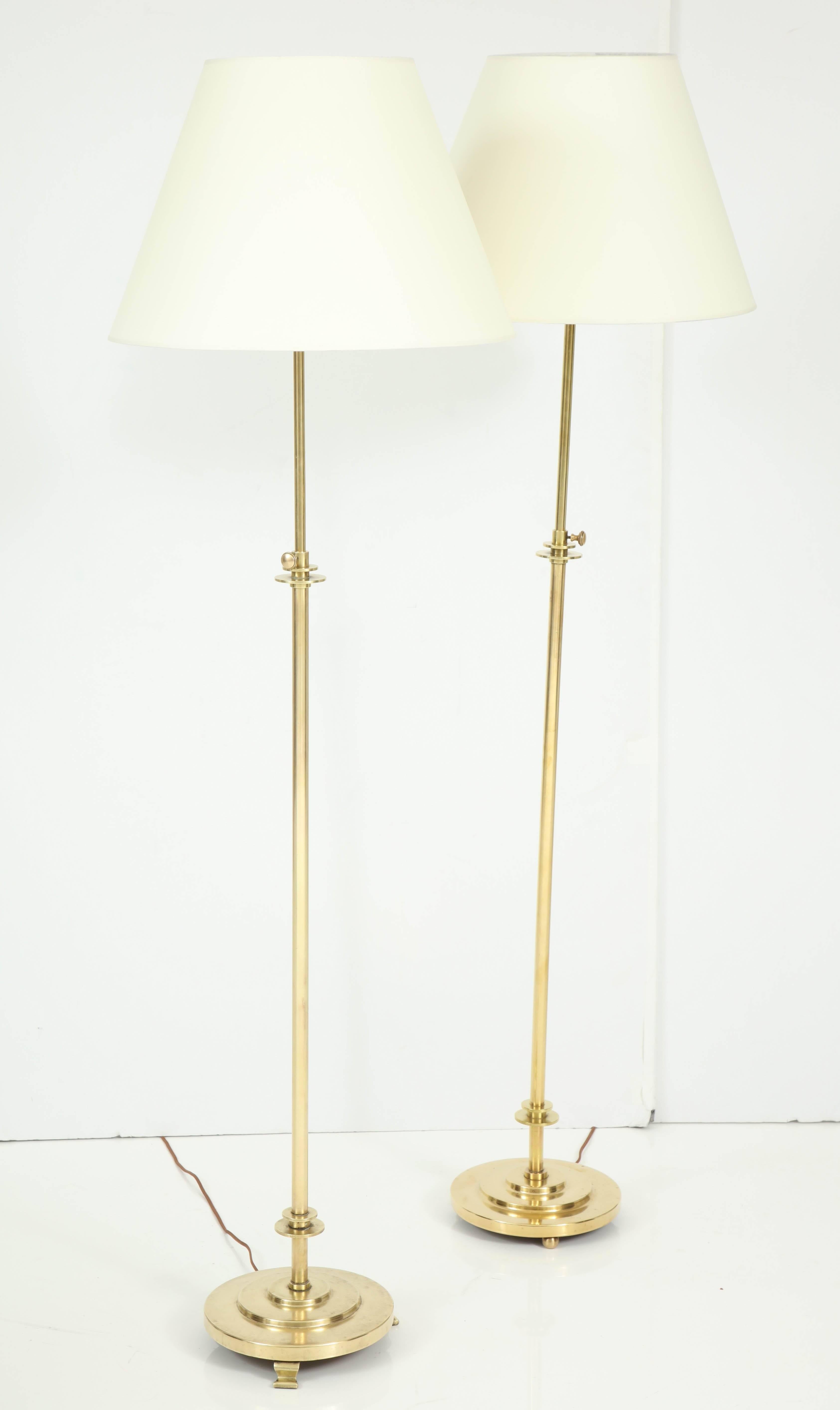A near pair of brass floor lamps, Copenhagen, circa 1930s, with adjustable circular stems raised on stepped circular bases. Different feet. 

Can be purchased individually. Re-wired for the US.
