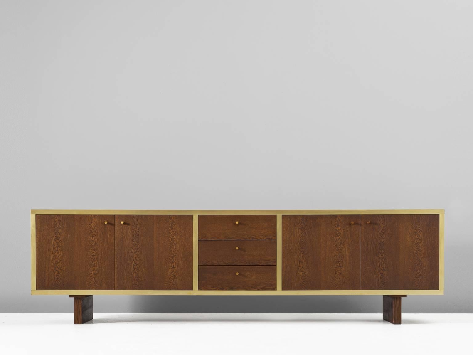 Sideboard, in stained oak and brass, for Van den Berghe-Pouvers PVBA, Belgium, 1960s. 

Sideboard in stained oak with soft yellow brass framing. Beautiful geometric credenza with four doors and three drawers and one shelve. This credenza
