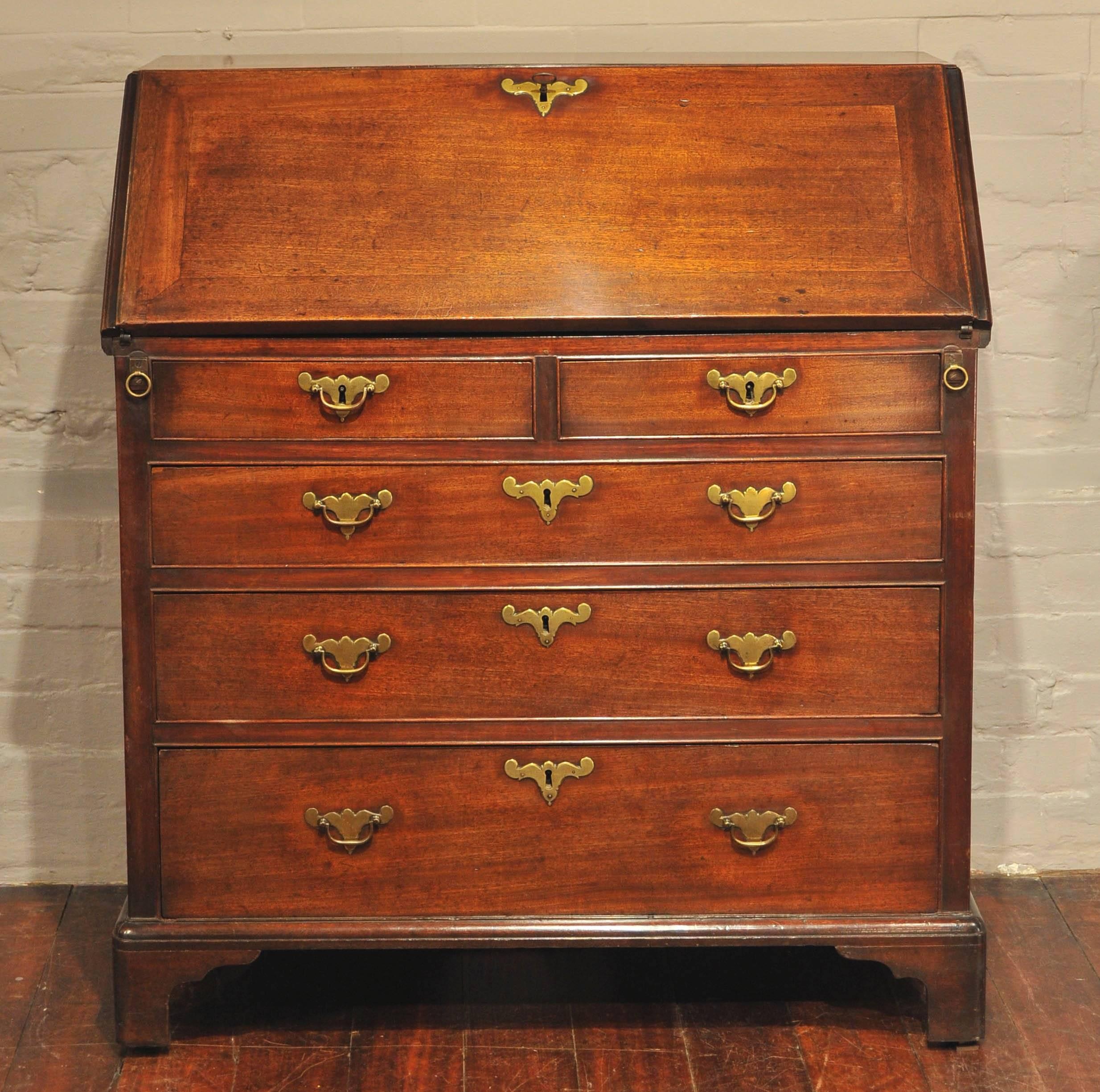 The beautifully fitted interior with secret compartments, herringbone inlay and classical column marquetry to the drawer and door fronts. The fall front, supported by lopers with their original ring pull handles, above two short and three long